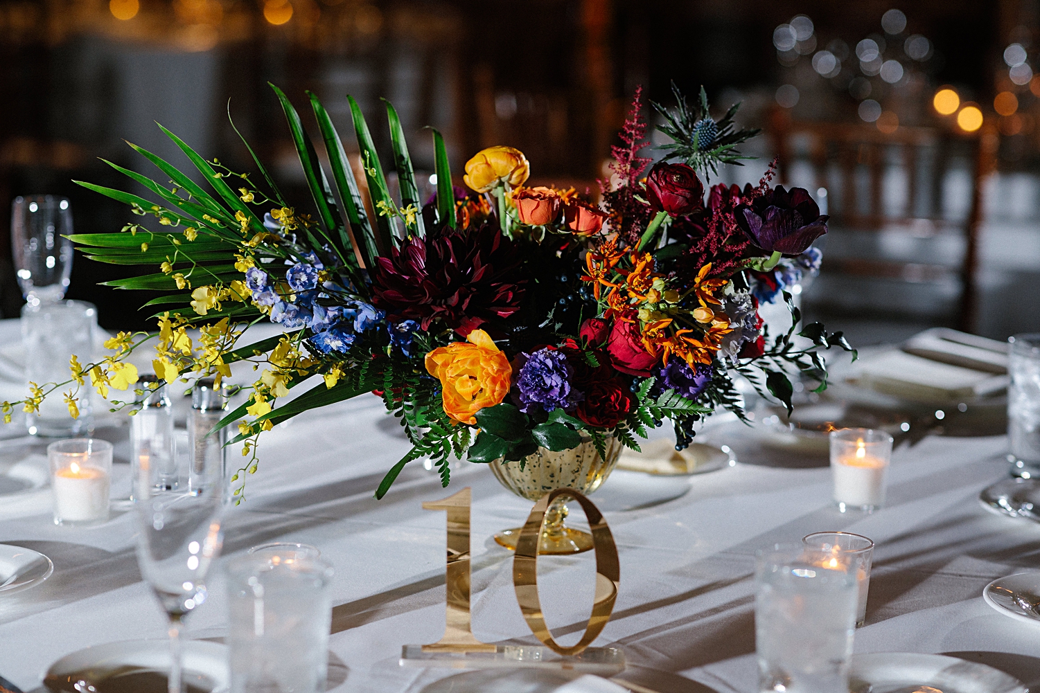 Wedding reception table top with colorful floral centerpiece