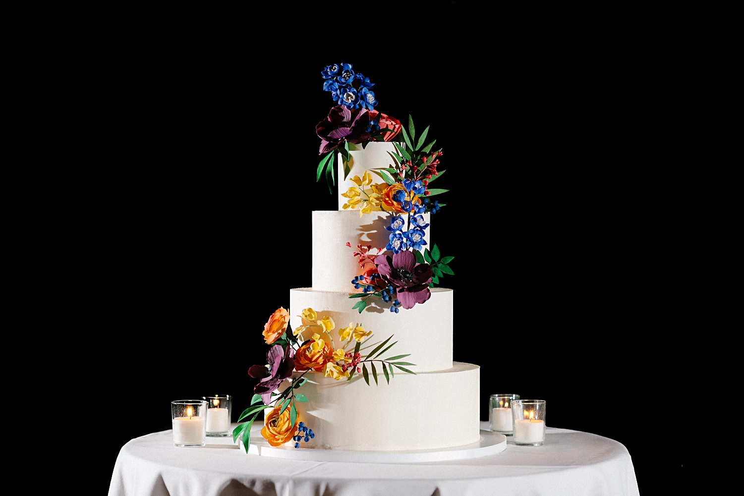 white three tier Wedding Cake with colorful edible flowers