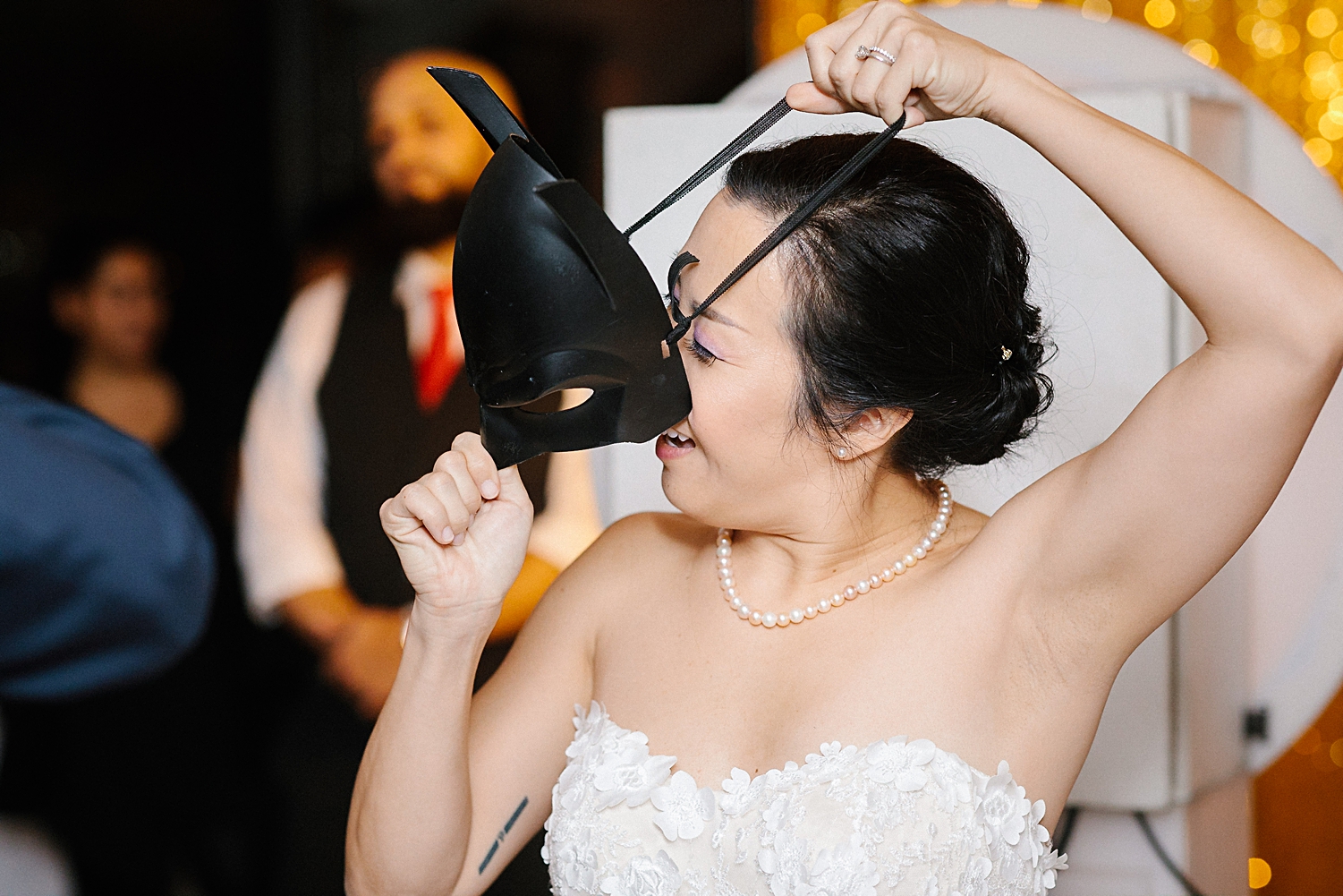 bride putting on batman mask at wedding reception