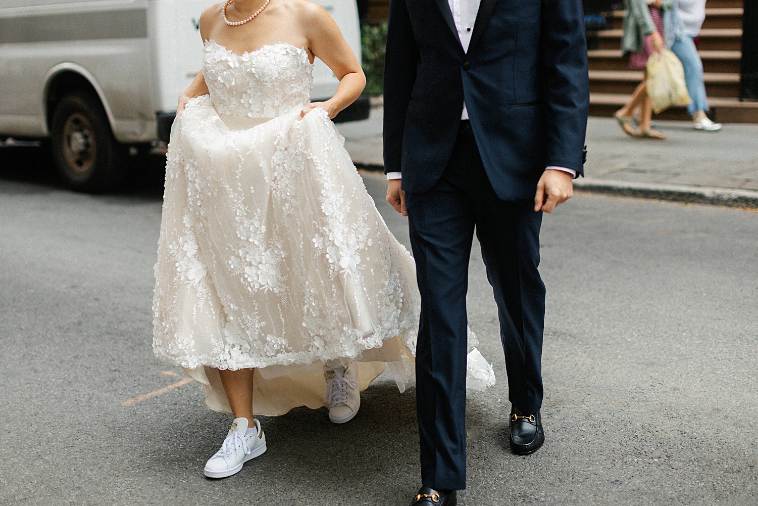 bride and groom walking across street lifting dress