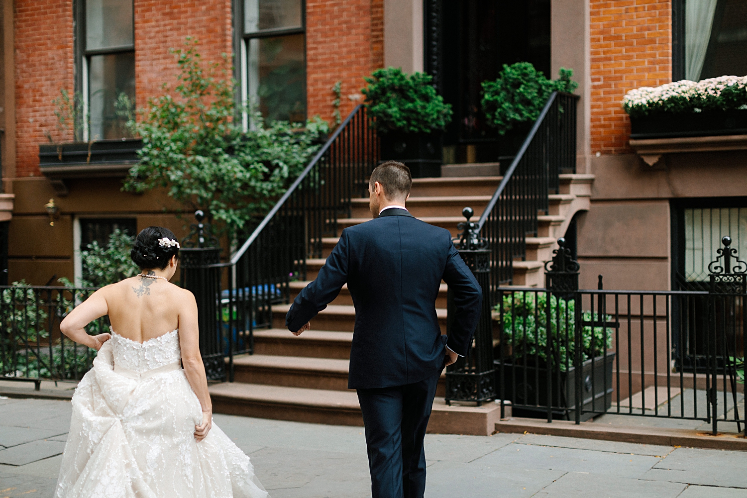 bride and groom walking on street in front of brownstone in new york city wedding
