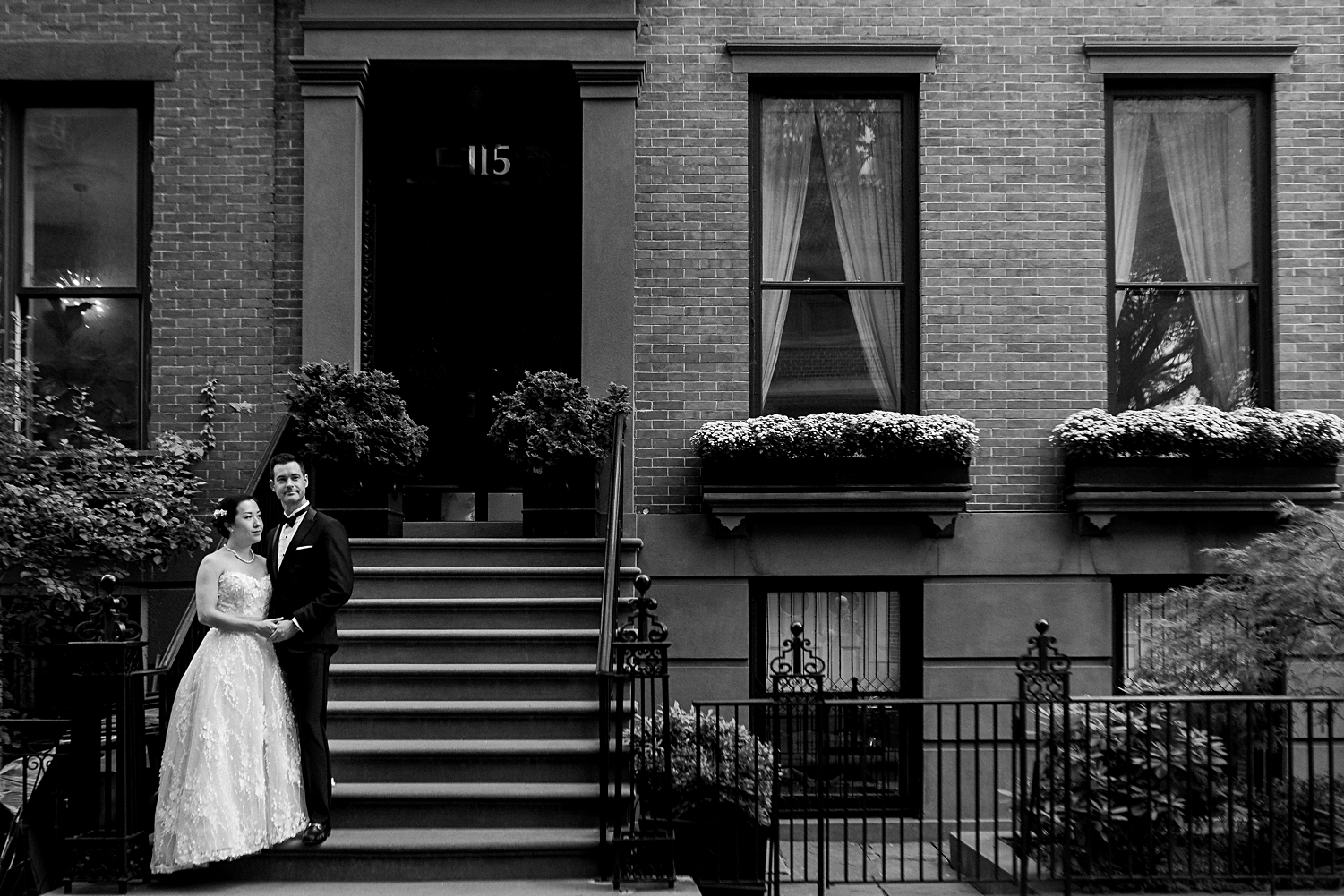 bride and groom standing in front of brownstone