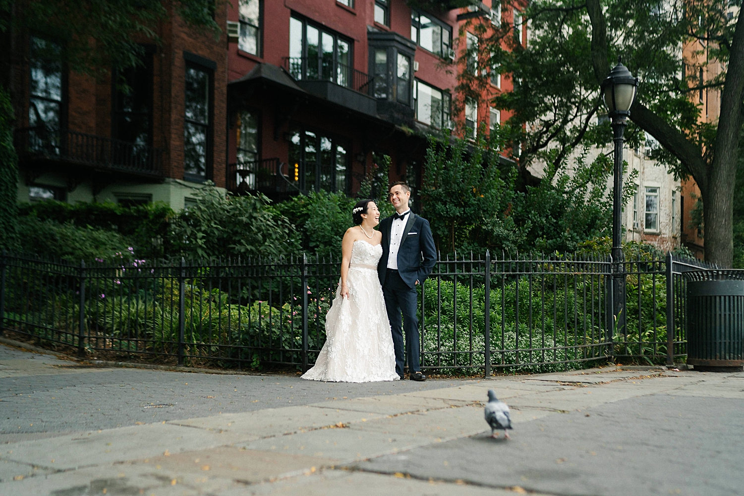 bride and groom standing in front of brooklyn brownstones  next to pigeon new york city wedding