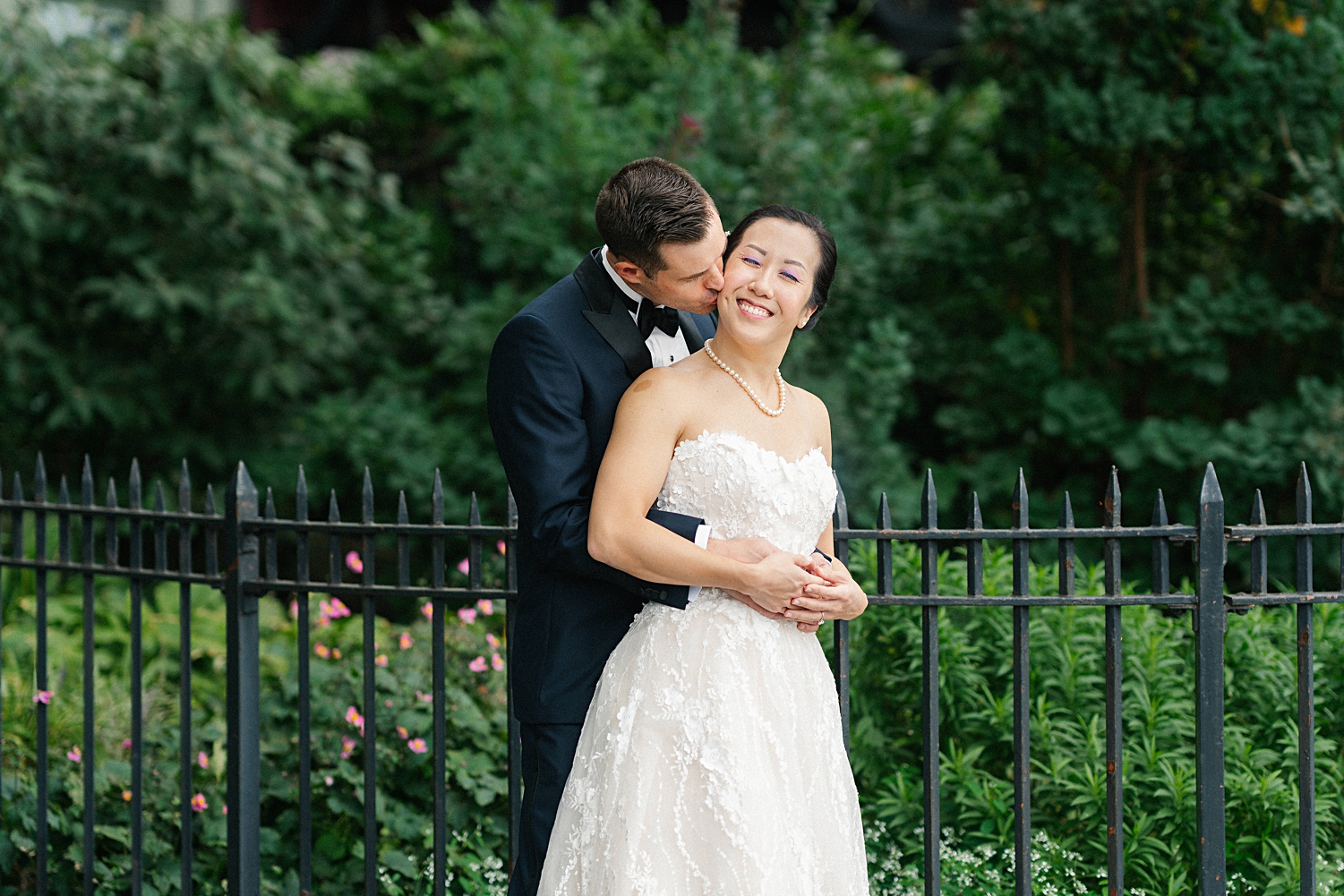 groom kissing groom in front of garden new york city wedding