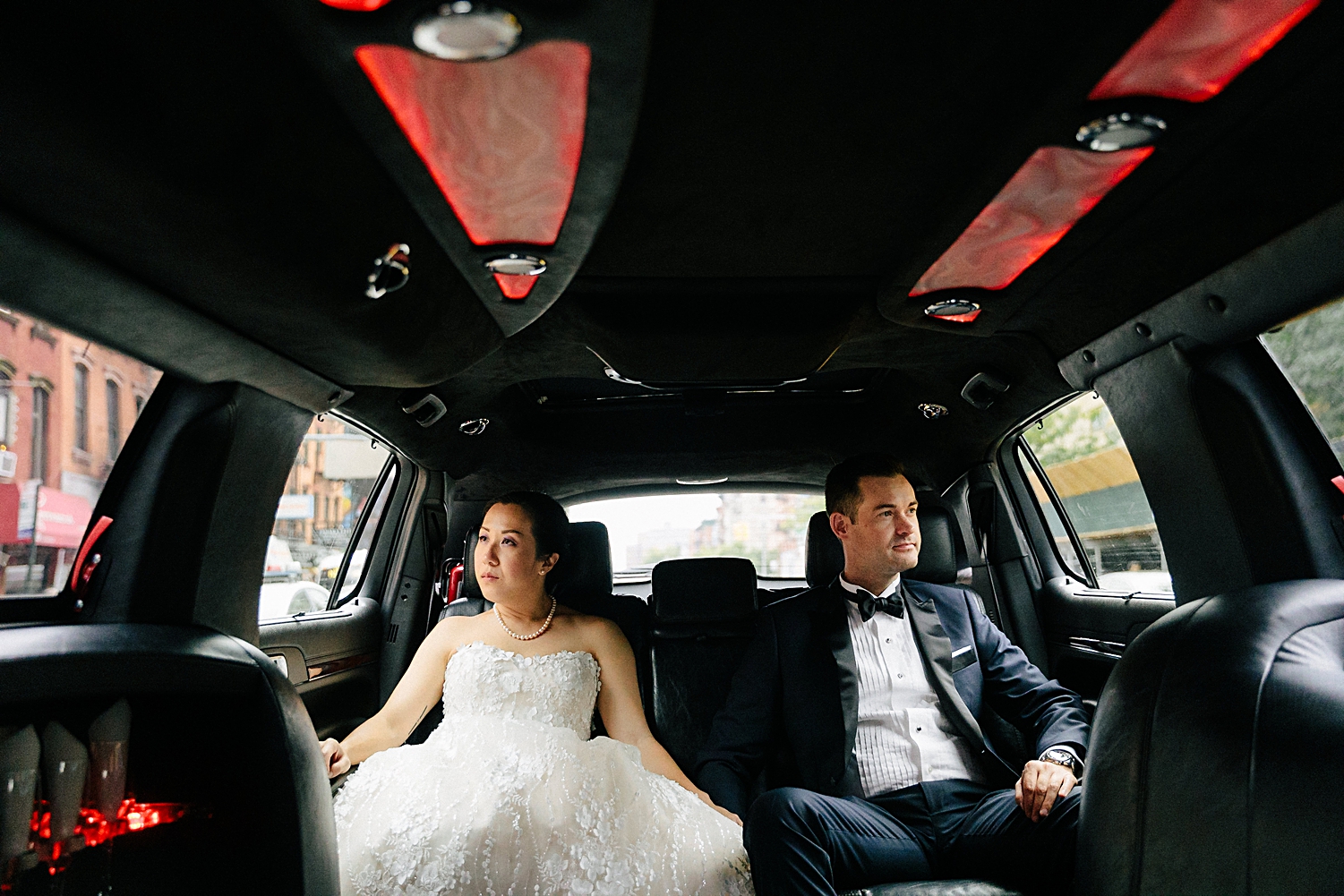 bride and groom sitting in the back of a limo