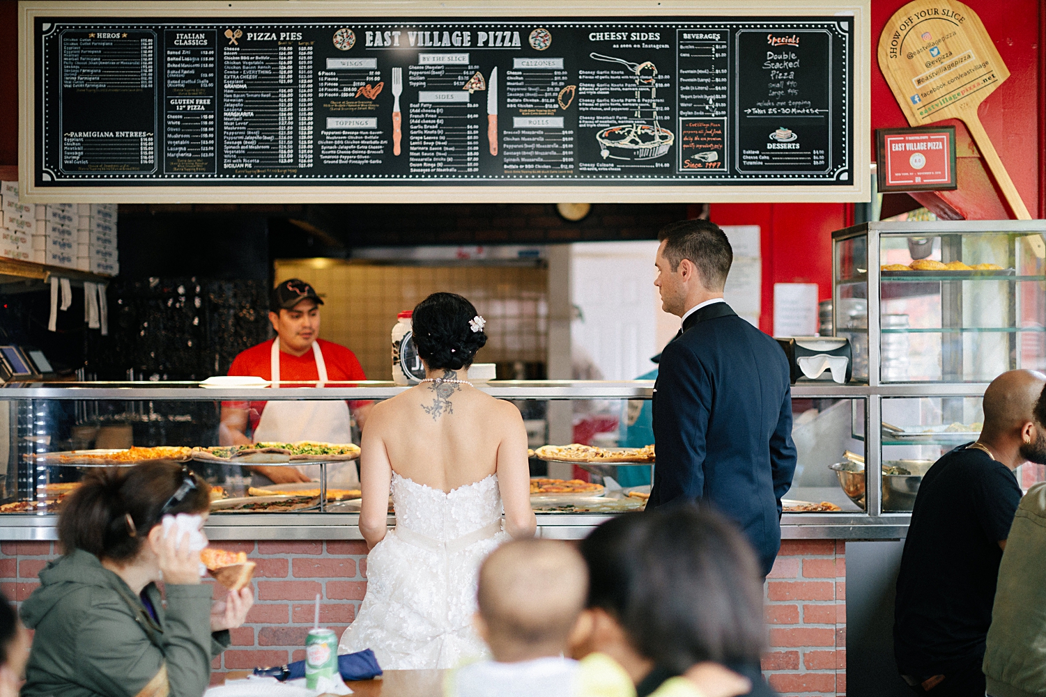 bride and groom ordering in new york city pizza restaurant 