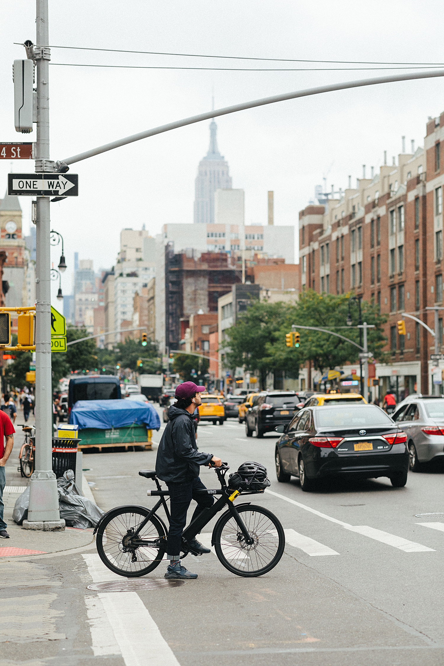man on bike looking to cross the road in new york