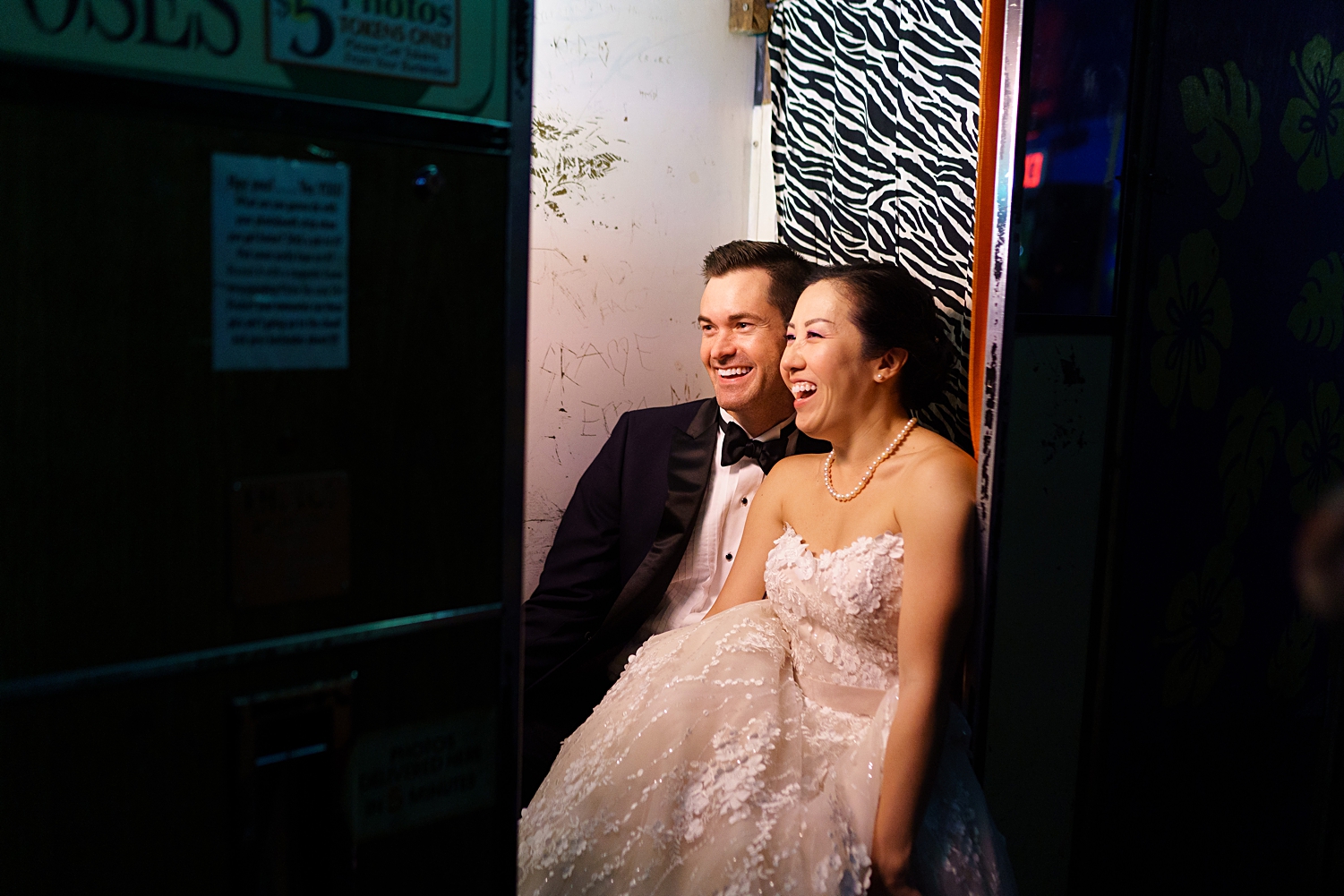 bride and groom making funny faces in old photo booth