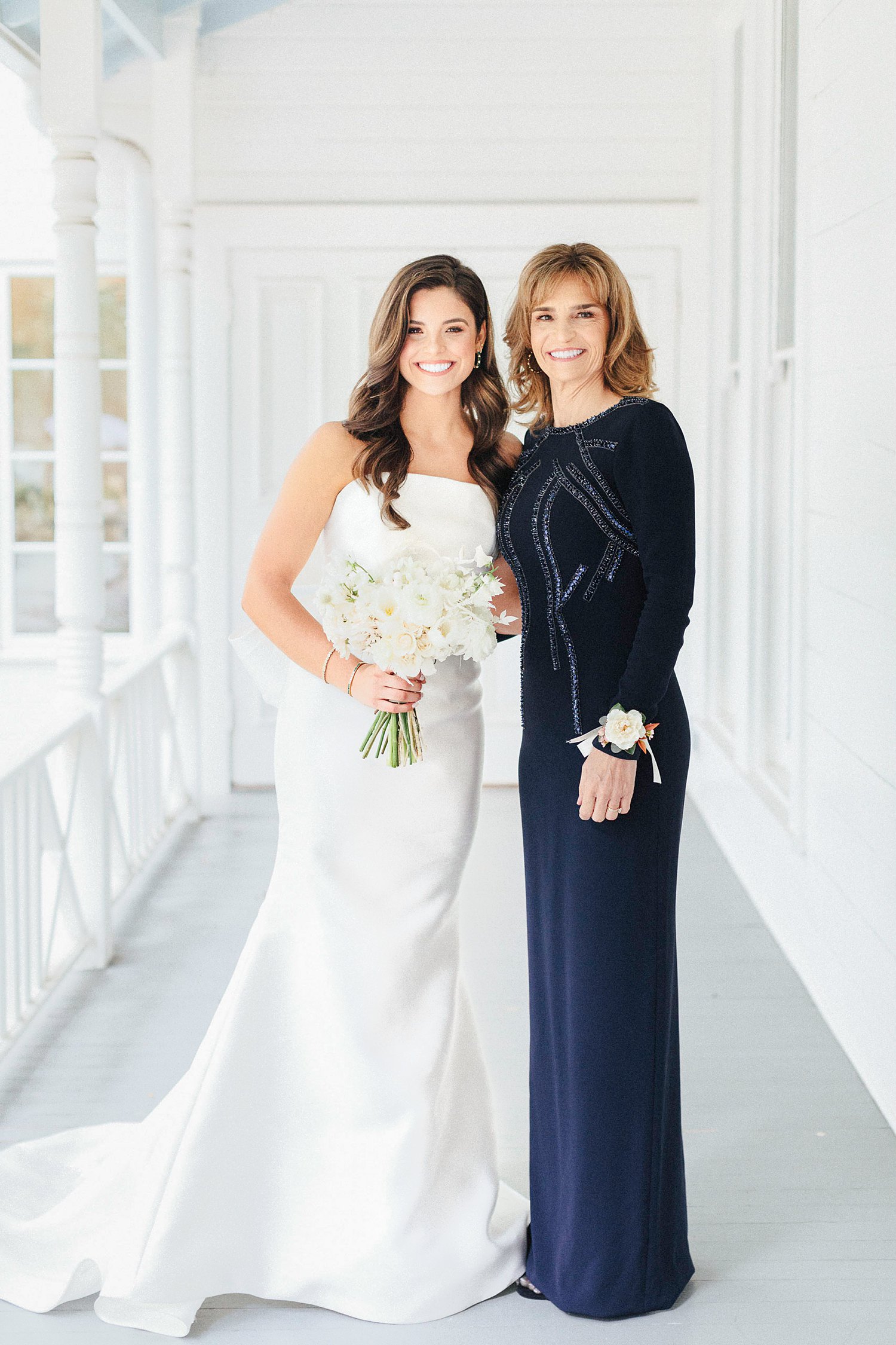 bride and mother posing together blue and white wedding dress