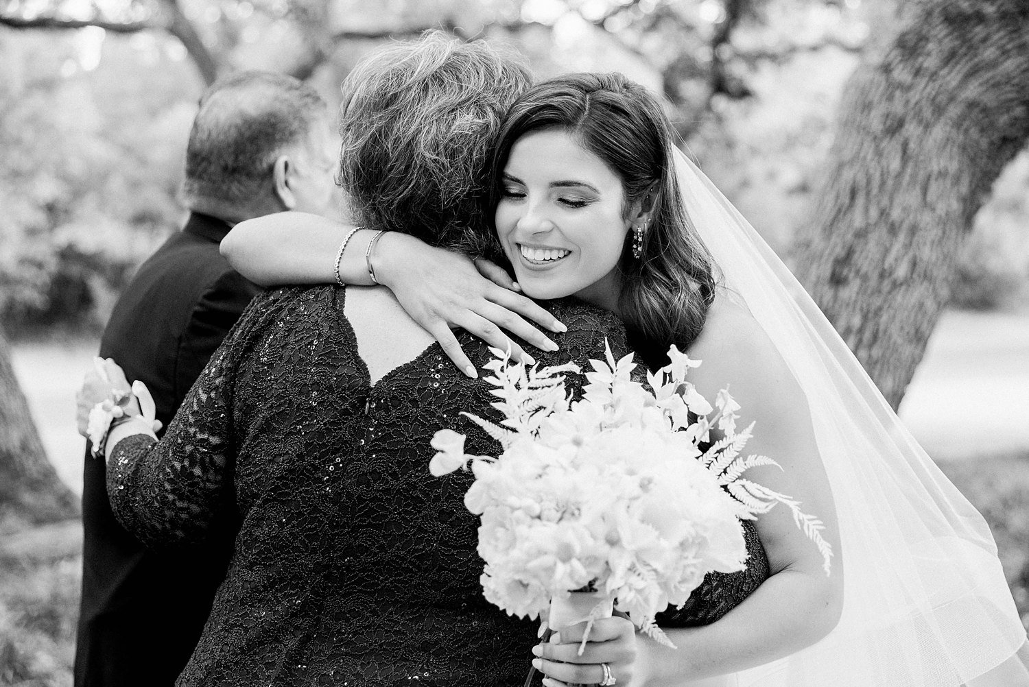 Bride hugging mom at wedding black and white