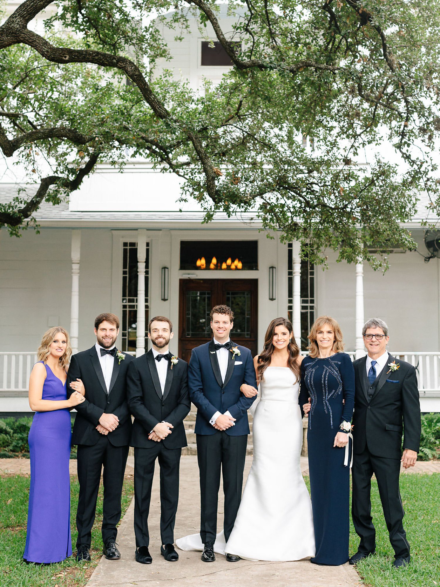 Bride groom and family posing on wedding day outside white house austin texas