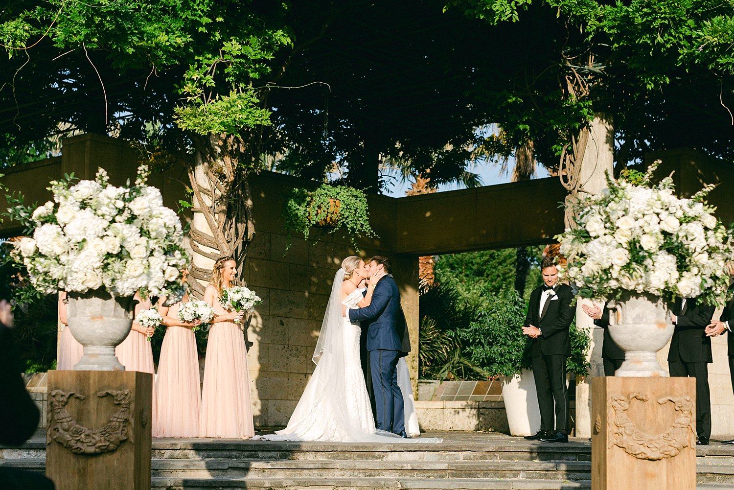 Bride and groom first kiss at ceremony altar Dallas Arboretum wedding