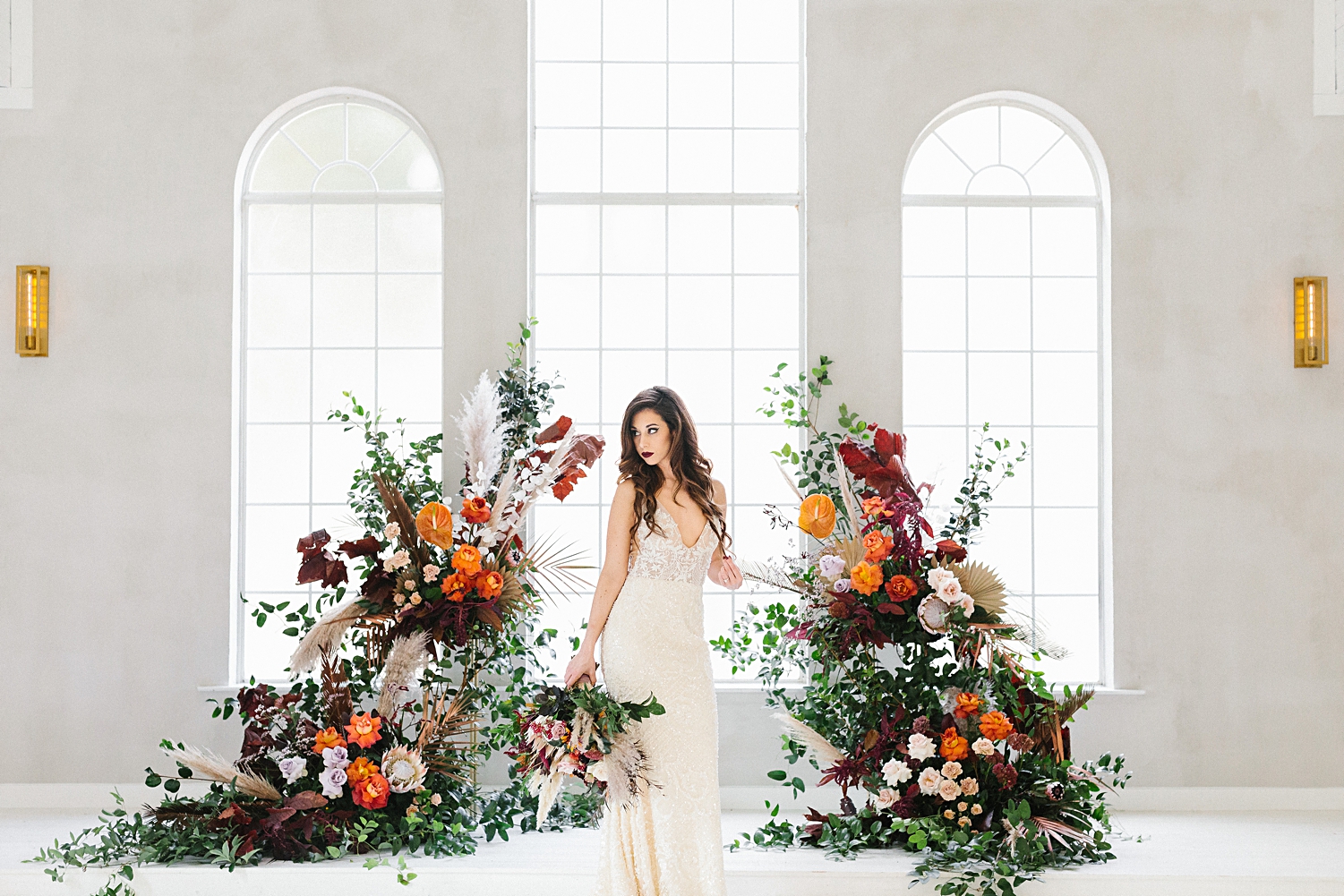 bride in dress standing at altar white chapel floral instillation Emerson wedding venue