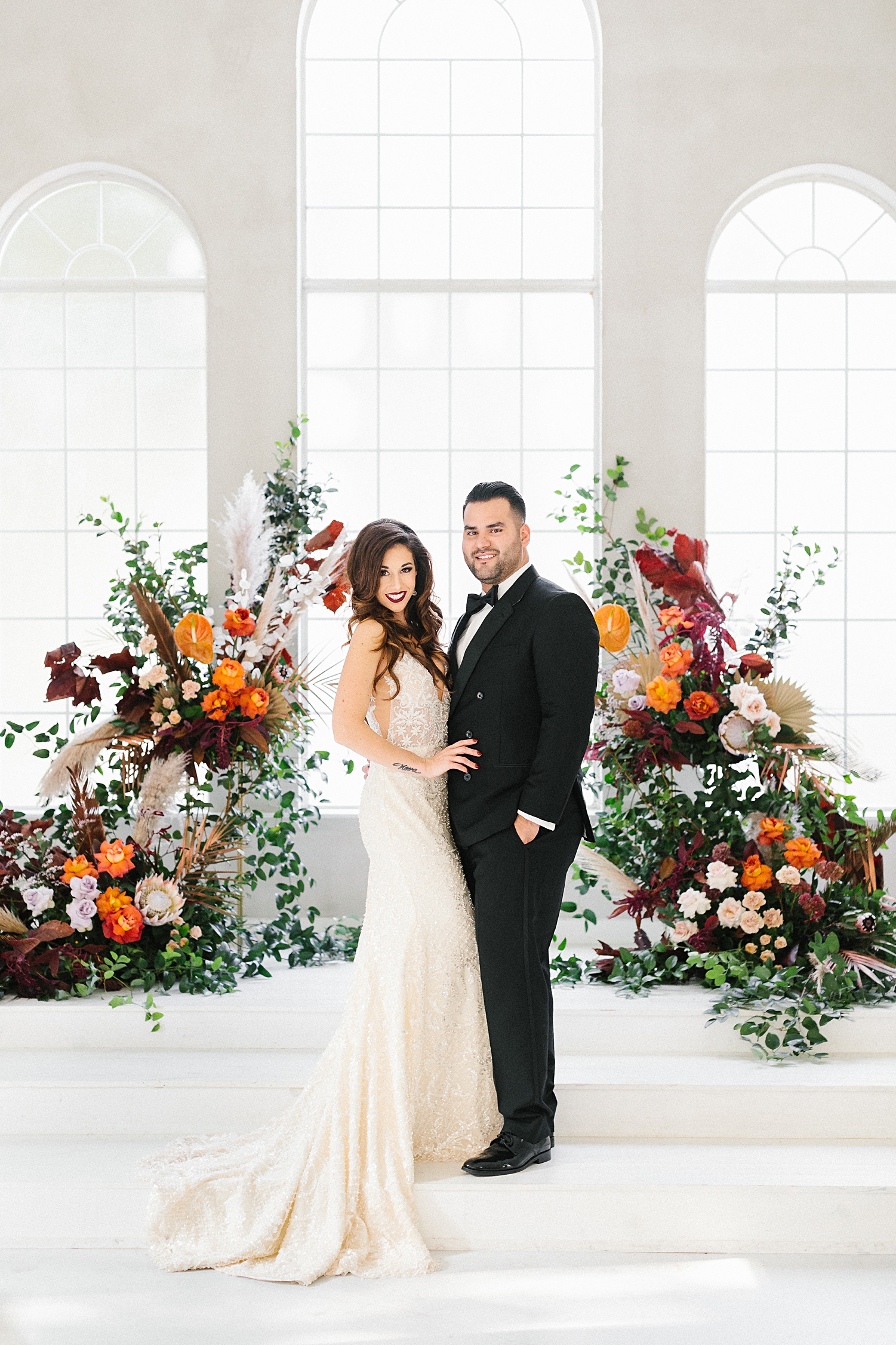 bride and groom standing at altar white chapel floral instillation Emerson wedding venue