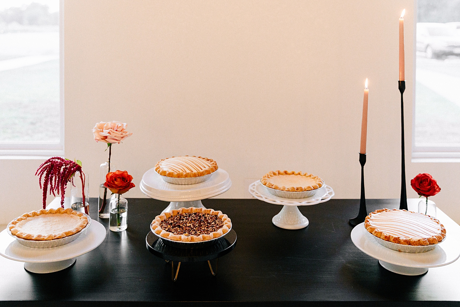 pies and red pink flowers on black table