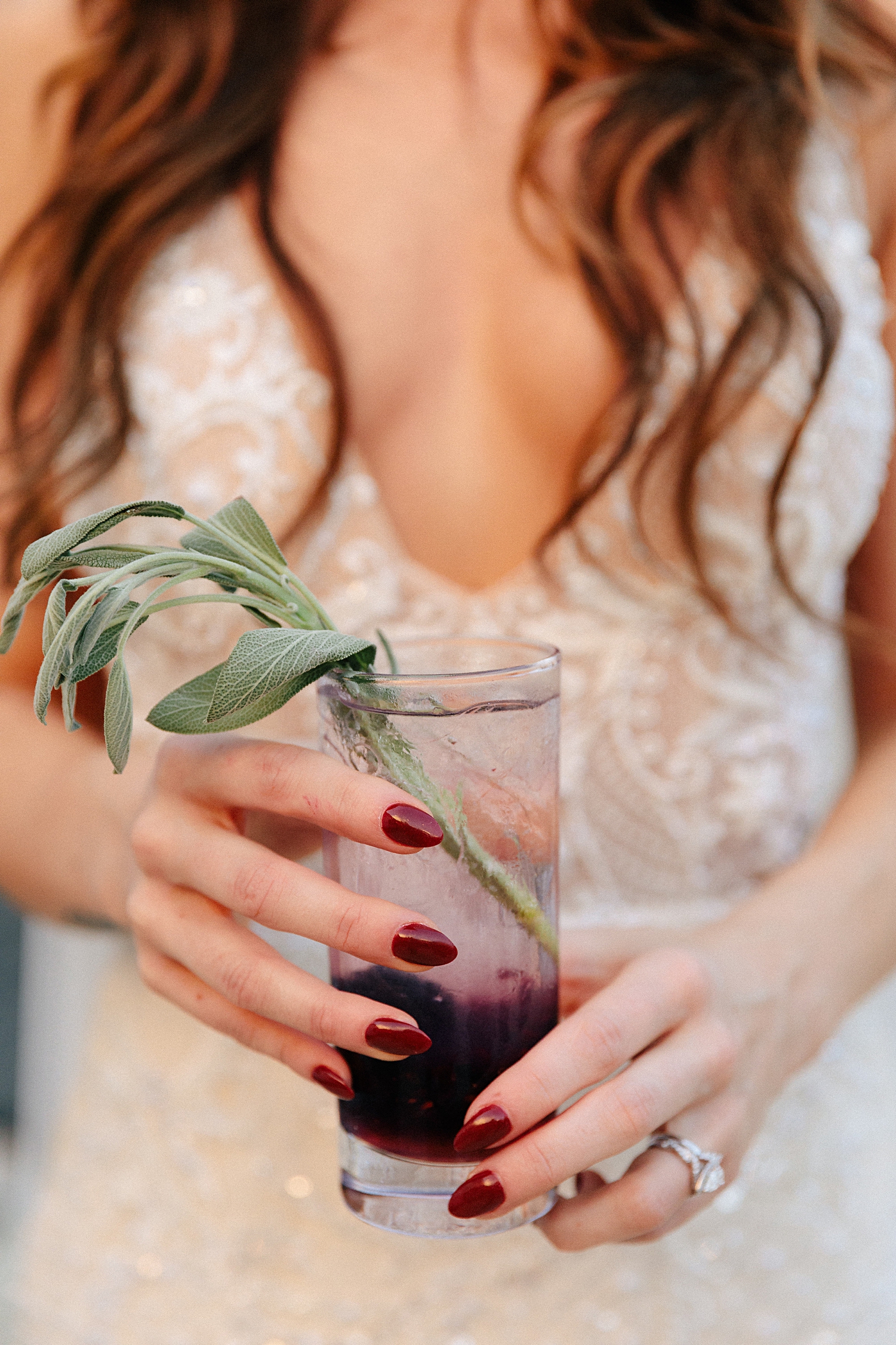 bride holding purple cocktail red nails