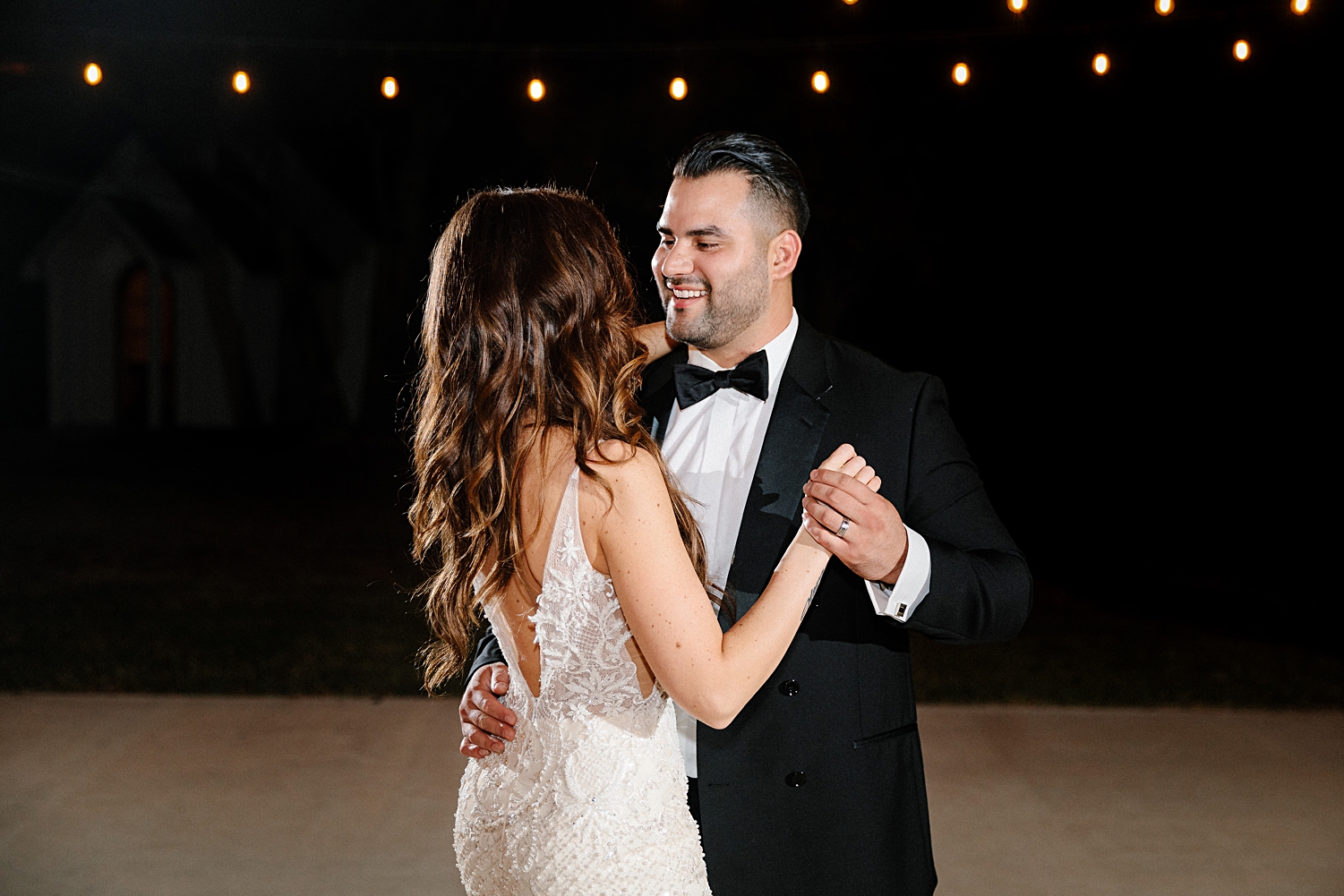 bride and groom dancing at night under string lights Emerson Venue Wedding