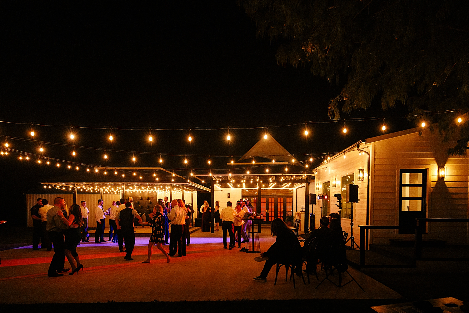 outdoor patio night dancing wedding reception Emerson venue orange lights