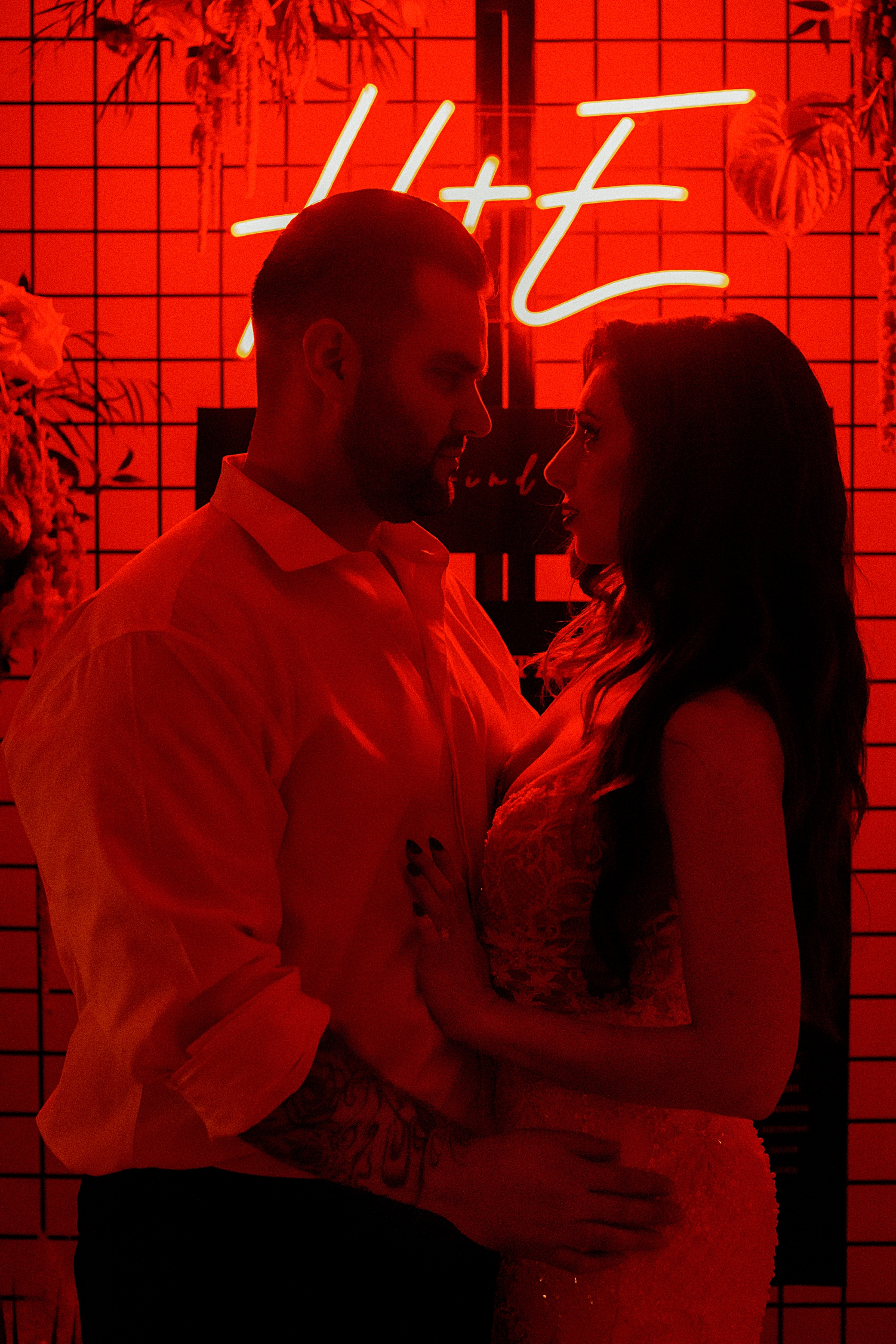 bride and groom in front of red neon light wedding reception