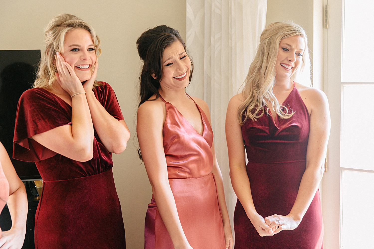 three bridesmaids in rose gold dresses smiling