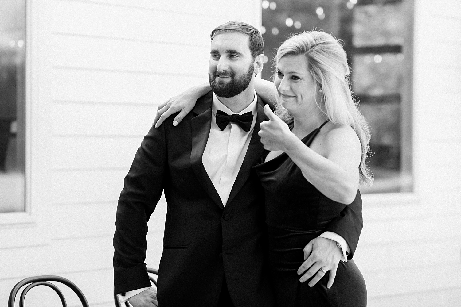 bridesmaid thumbs up arm around man in tuxedo black and white
