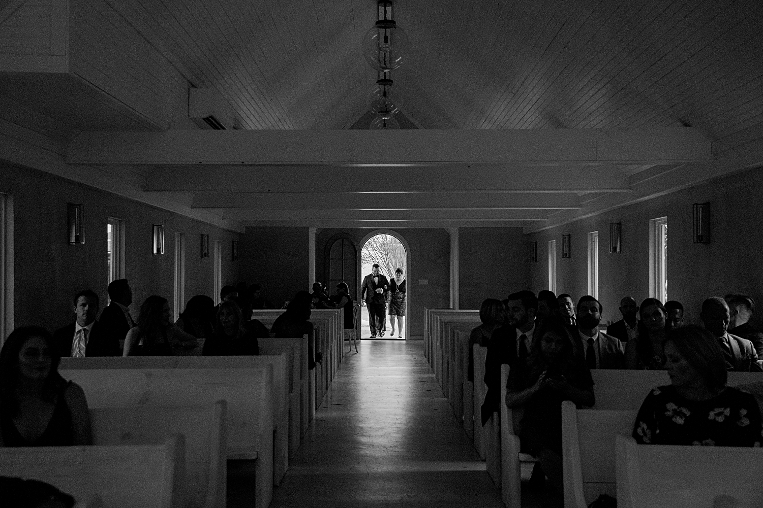 black and white groom entering chapel through doorway