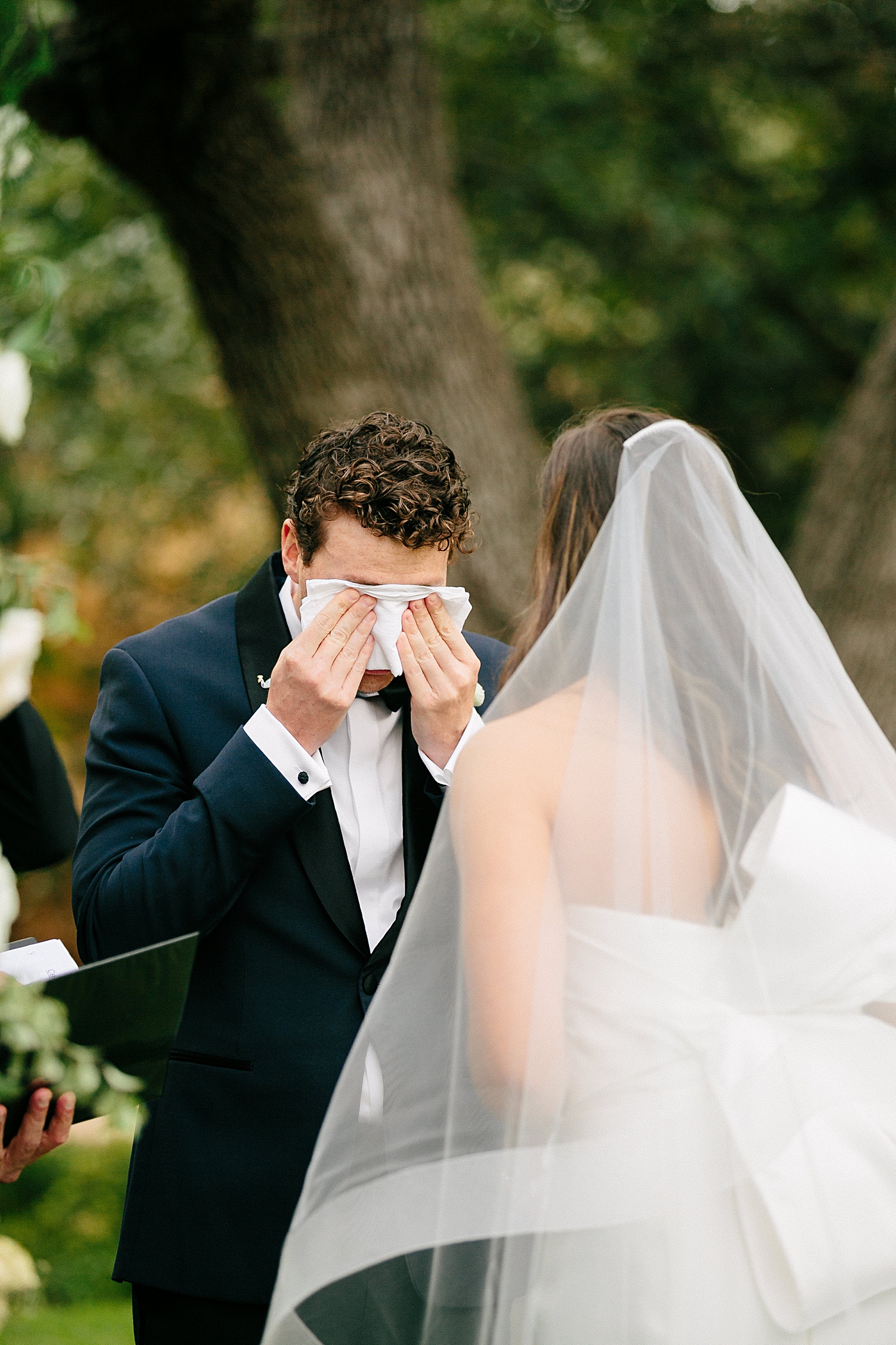 groom crying during bride reading vows at wedding ceremony altar Matties Austin