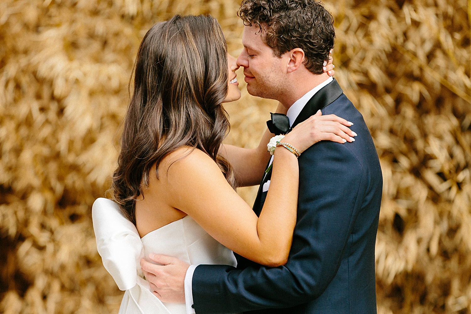 bride and groom embracing in front of golden plants Mattie's Austin wedding