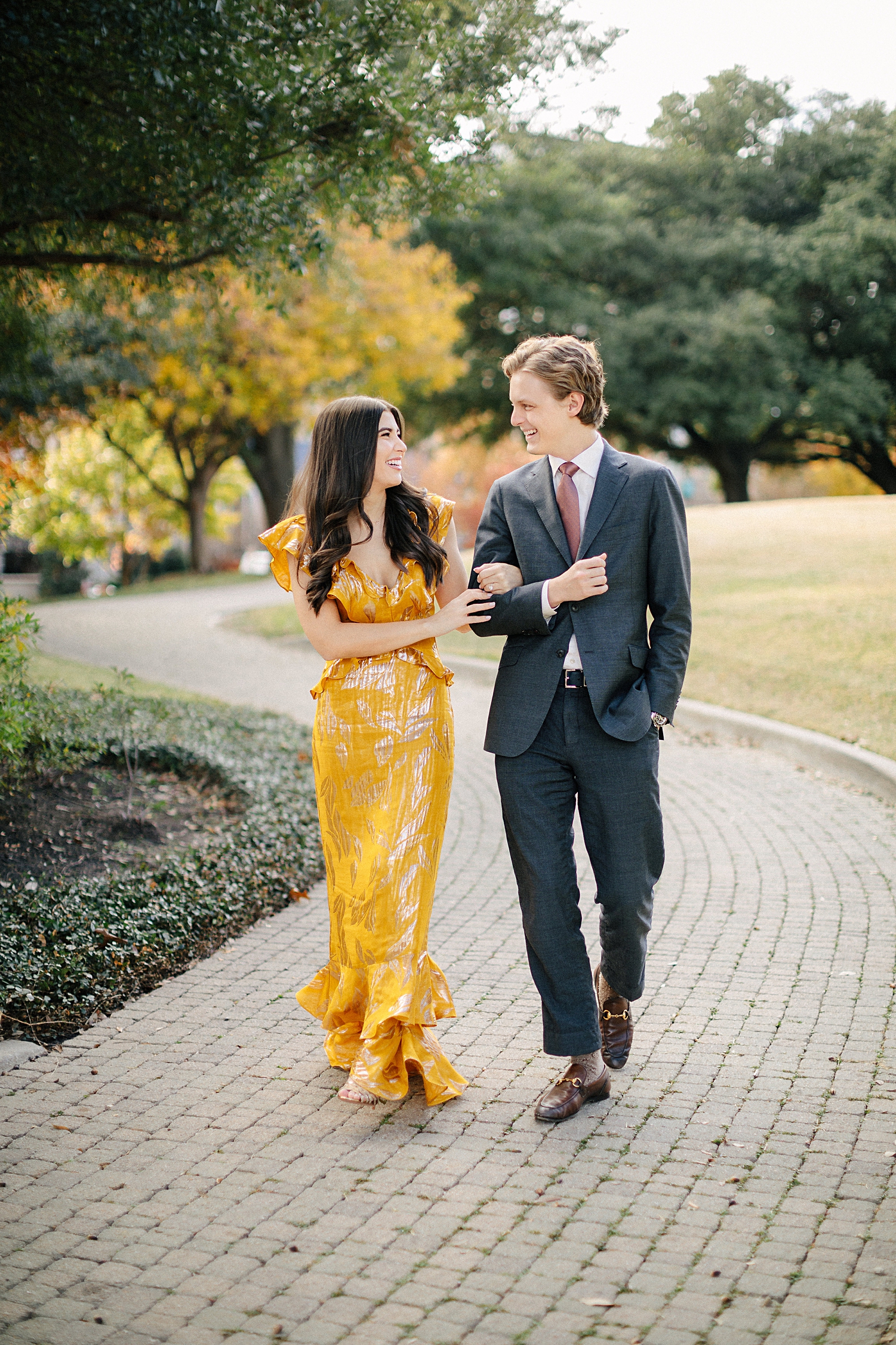 brunette girl in yellow dress walking with man in suit