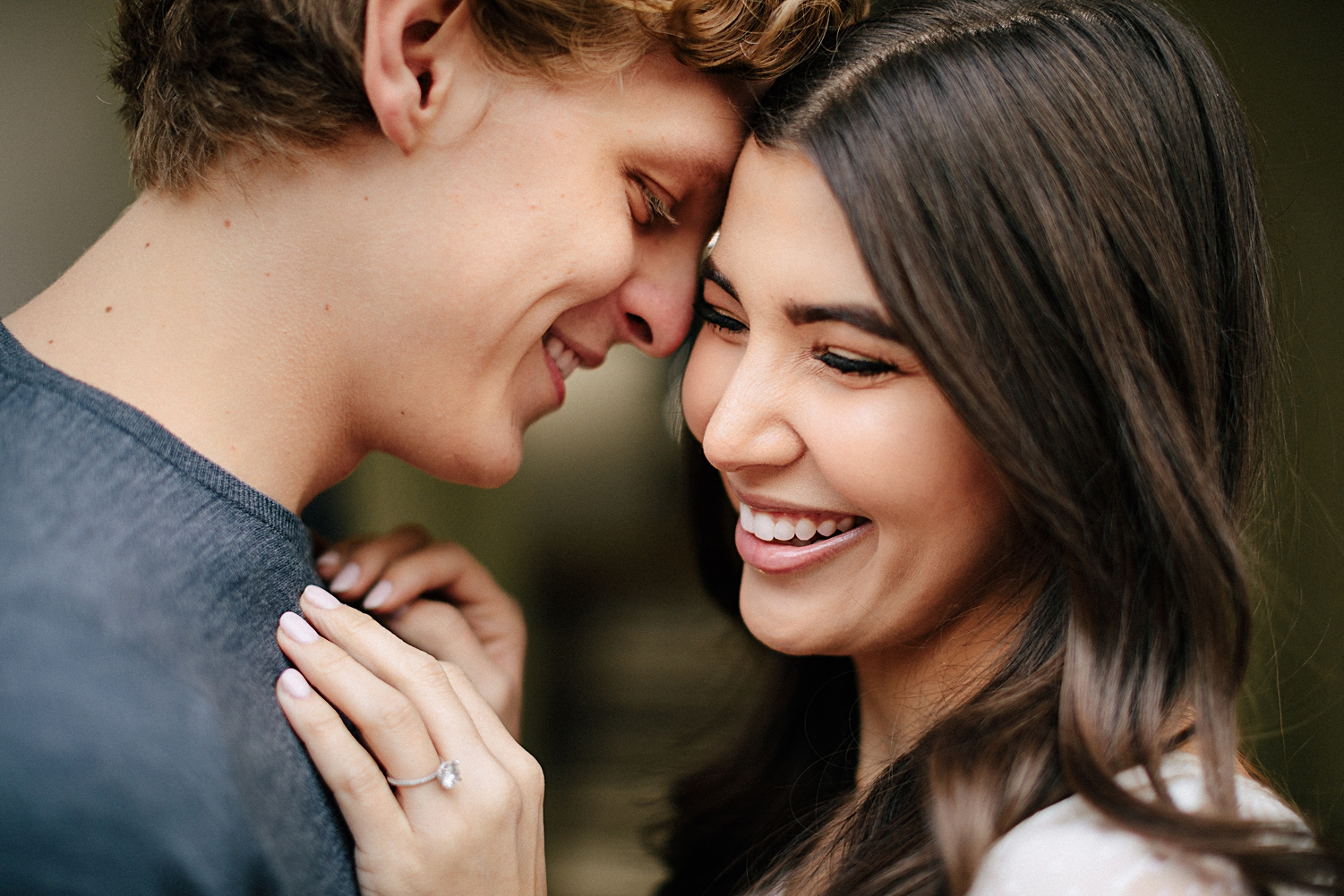 engaged couple embracing and smiling with heads together engagement