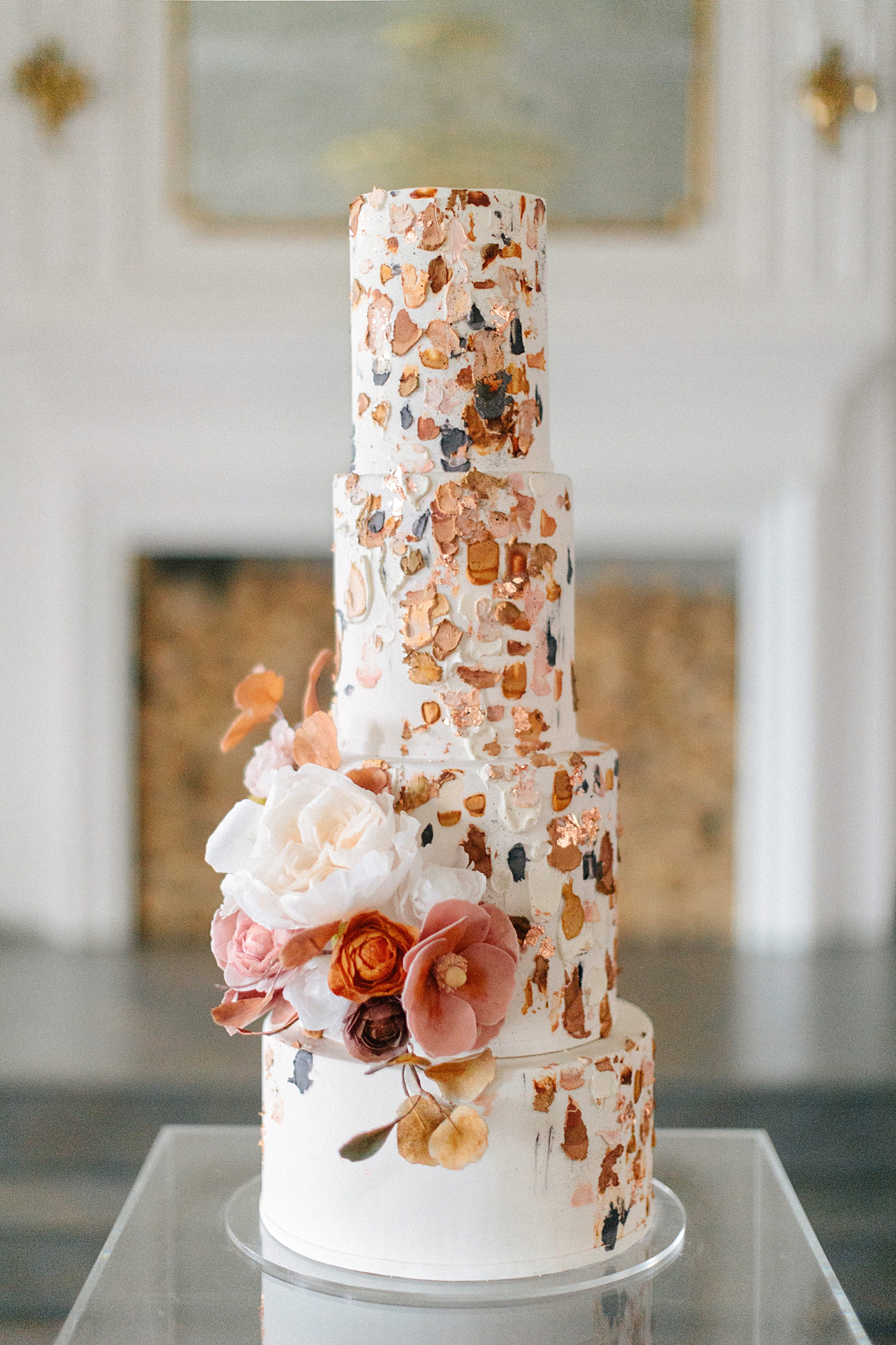 four tiered white wedding cake with orange, red flowers