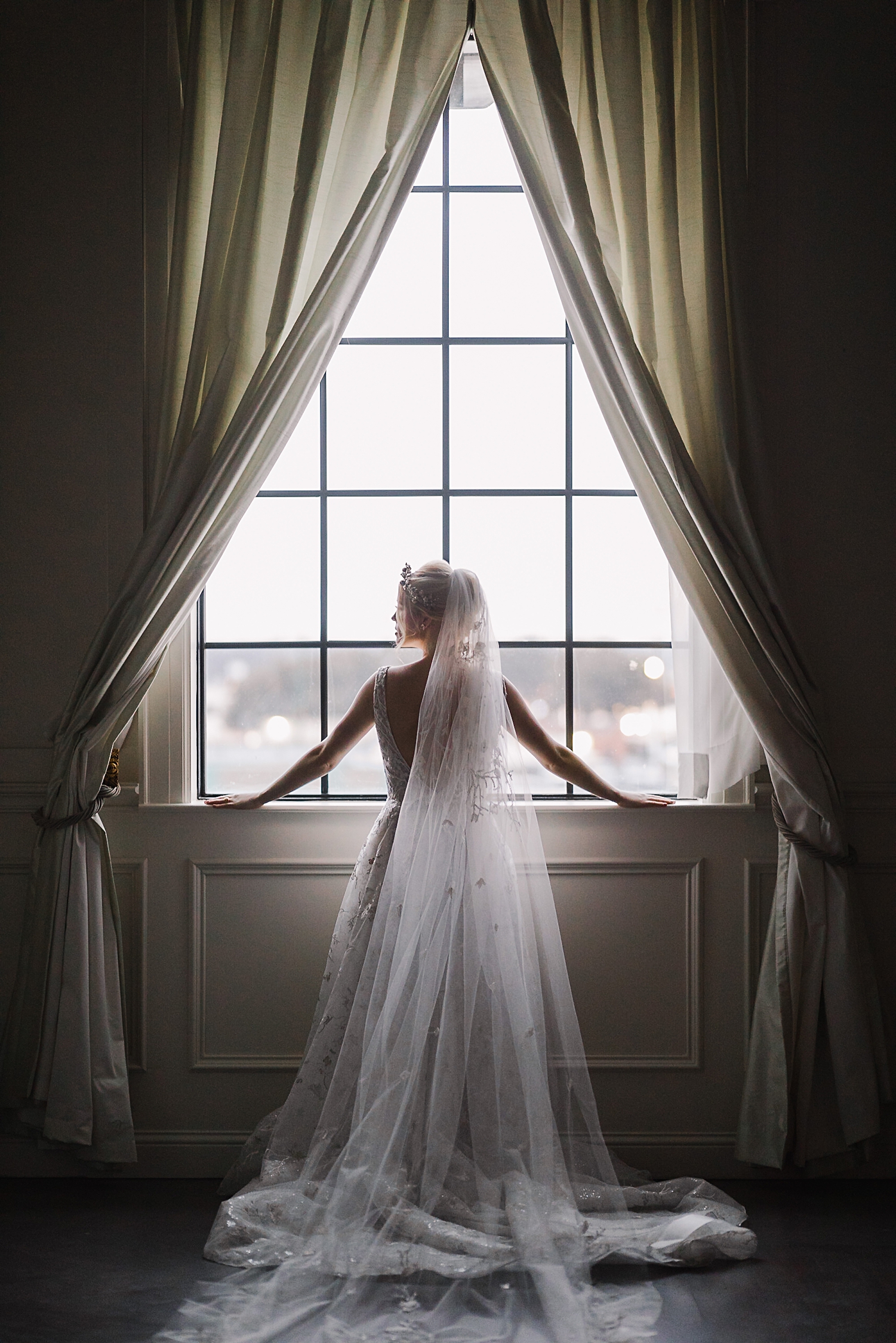 bride in white wedding dress long veil standing in front of window at The Mason Dallas