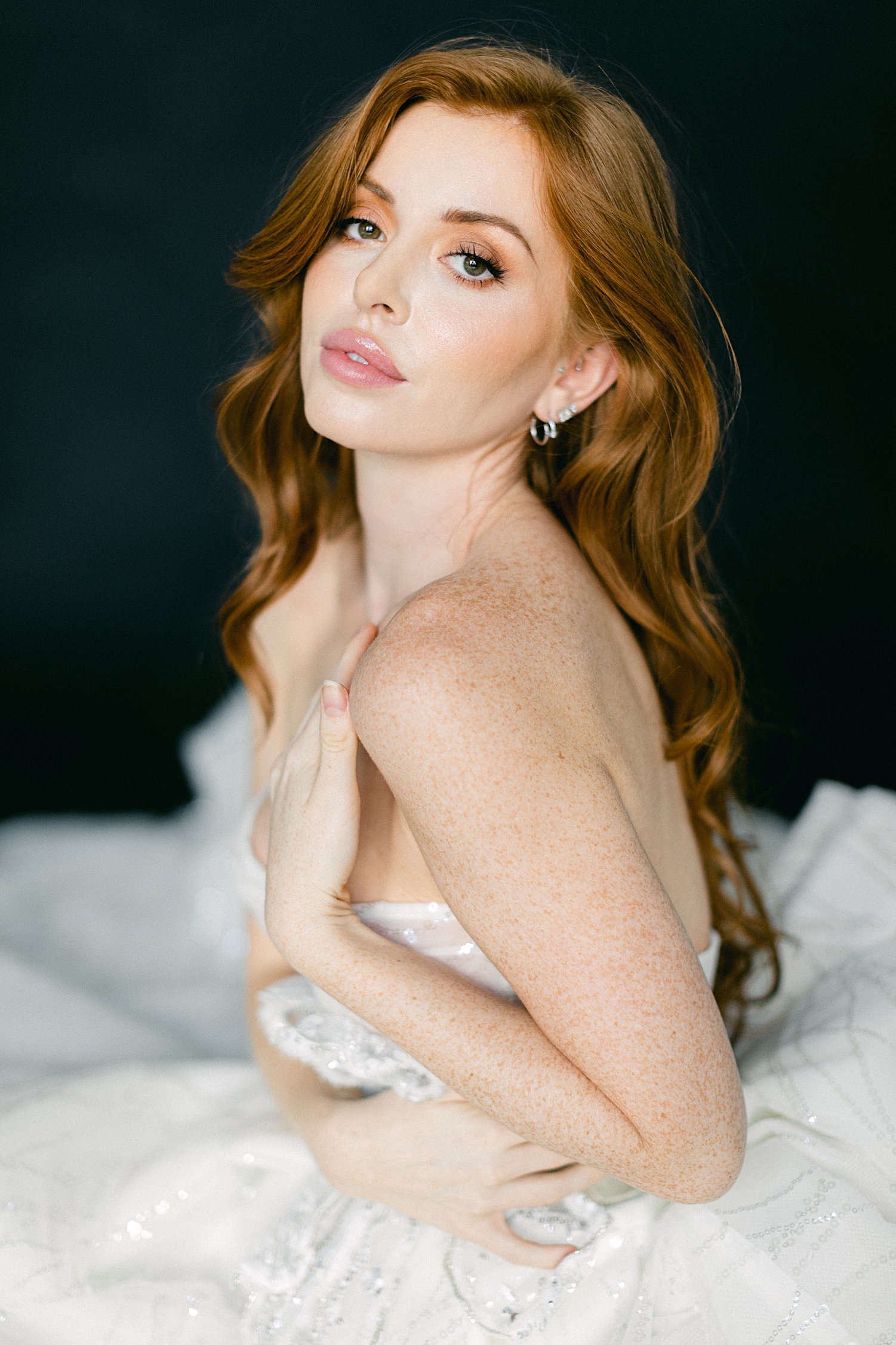 red headed girl in sparkling white wedding gown hand on chest