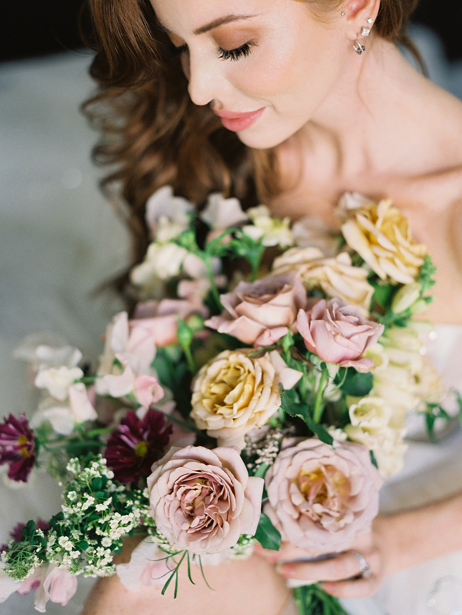 red headed bride holding colorful floral bouquet