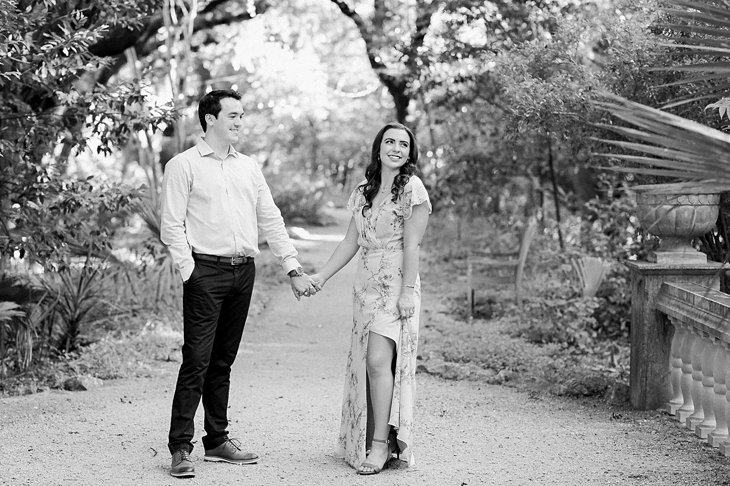 couple standing in forest holding hands black and white
