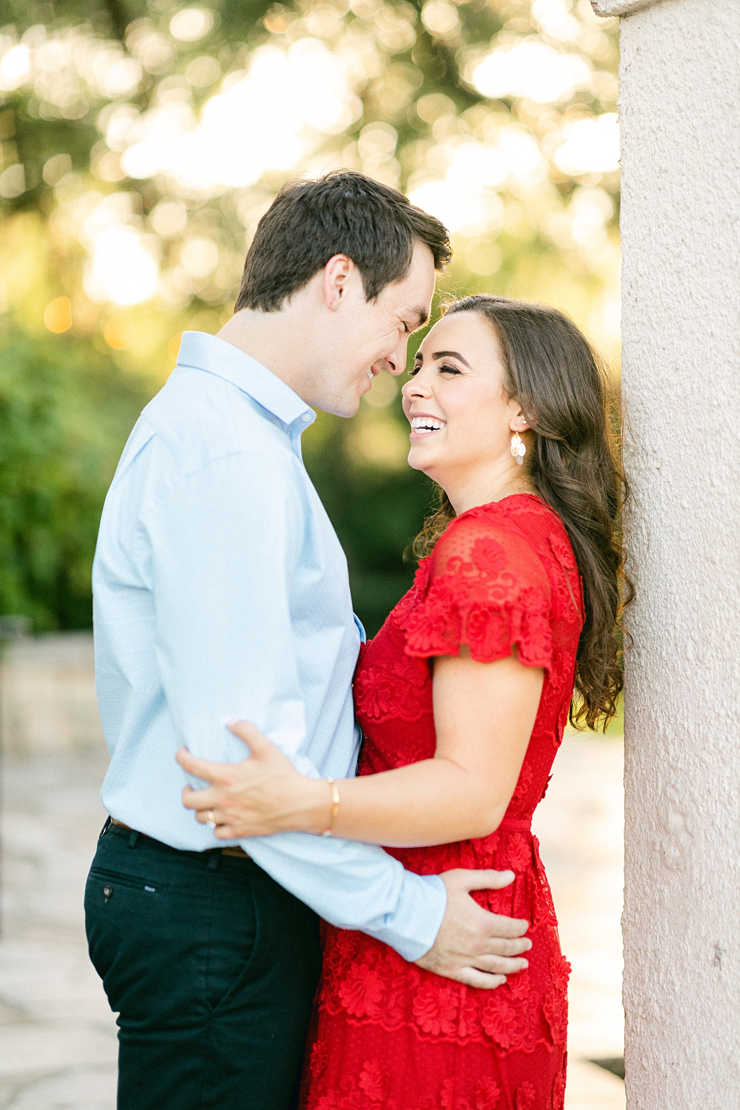 Man and woman in red dress embracing smiling Laguna Gloria