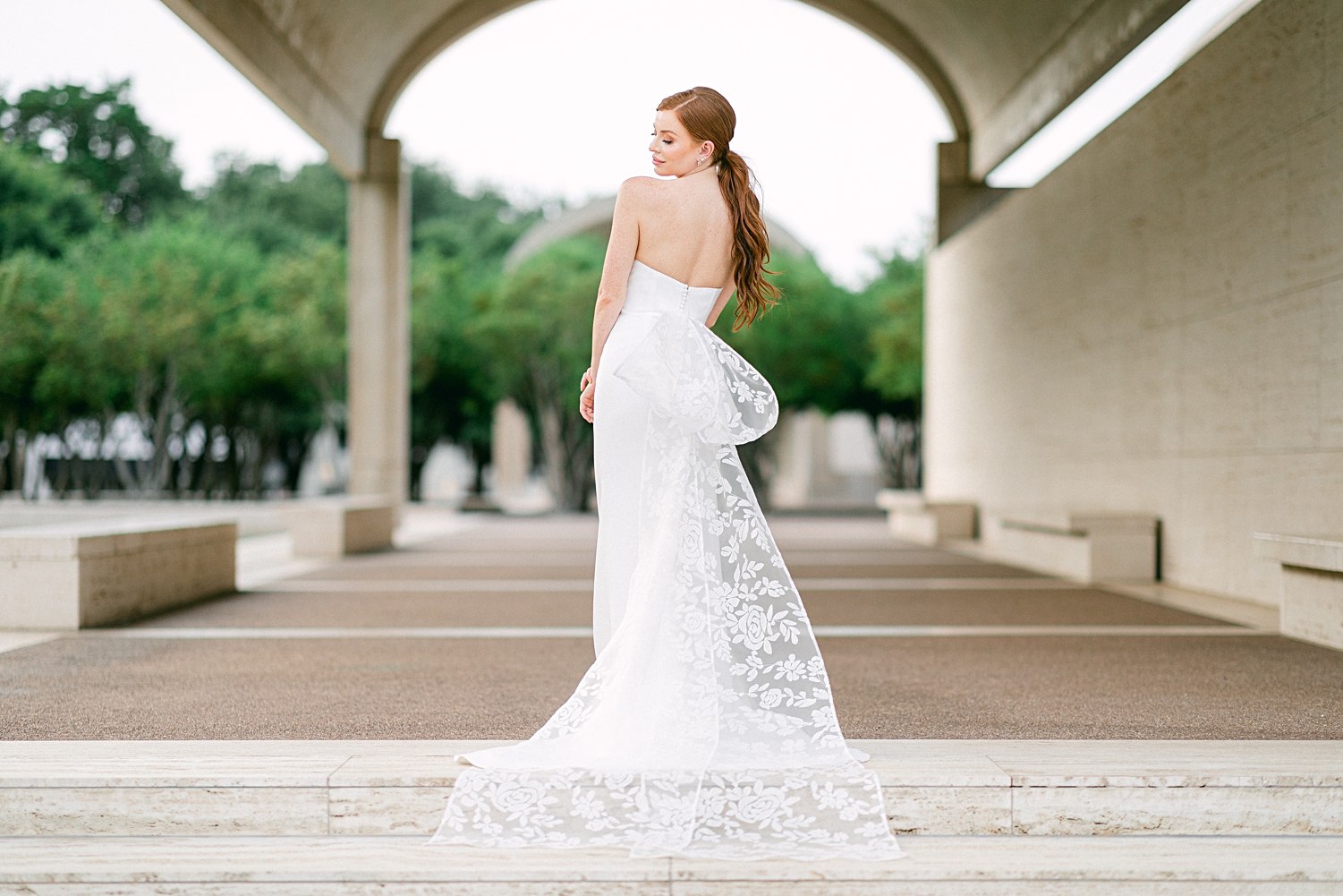 red headed bride in white Sareh Nouri bridal gown with lace bow on stairs