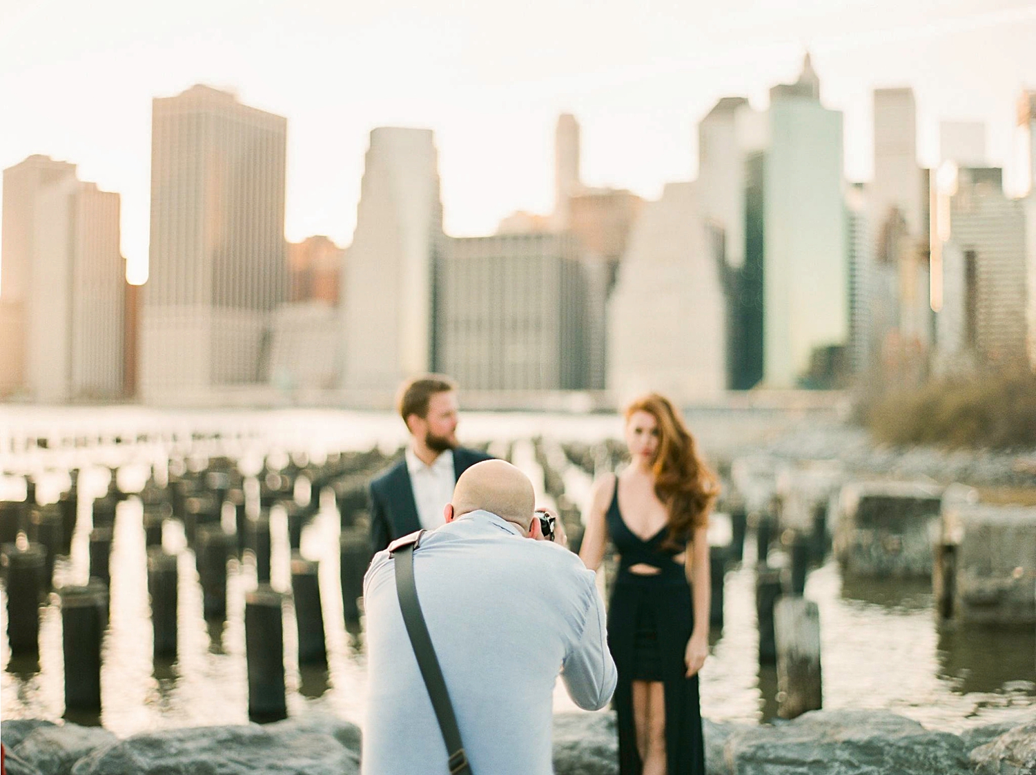 Photographer Jeff taking photo of couple in front of downtown manhattan skyline