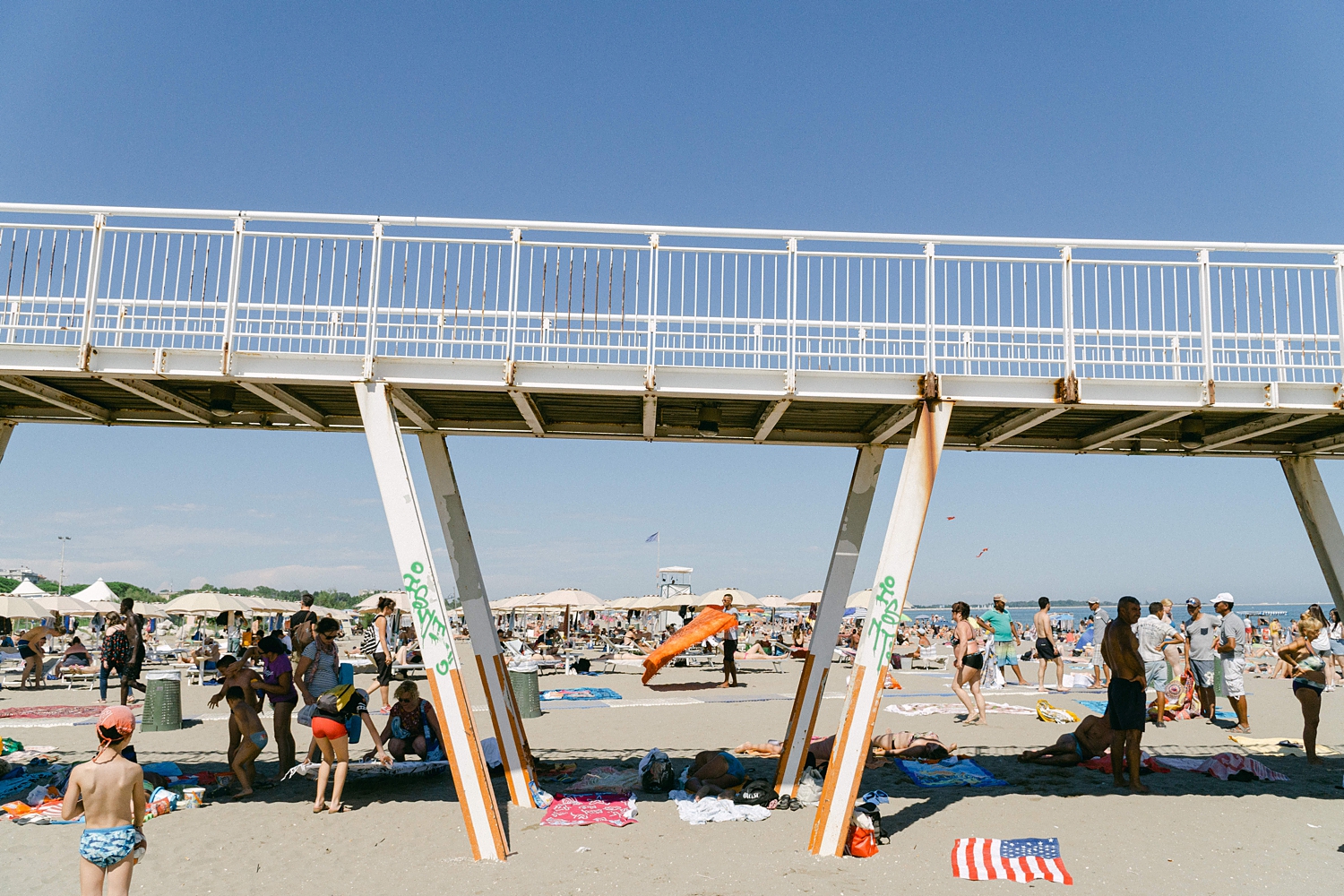 Lido Beach walkway with sunbathers in Italy