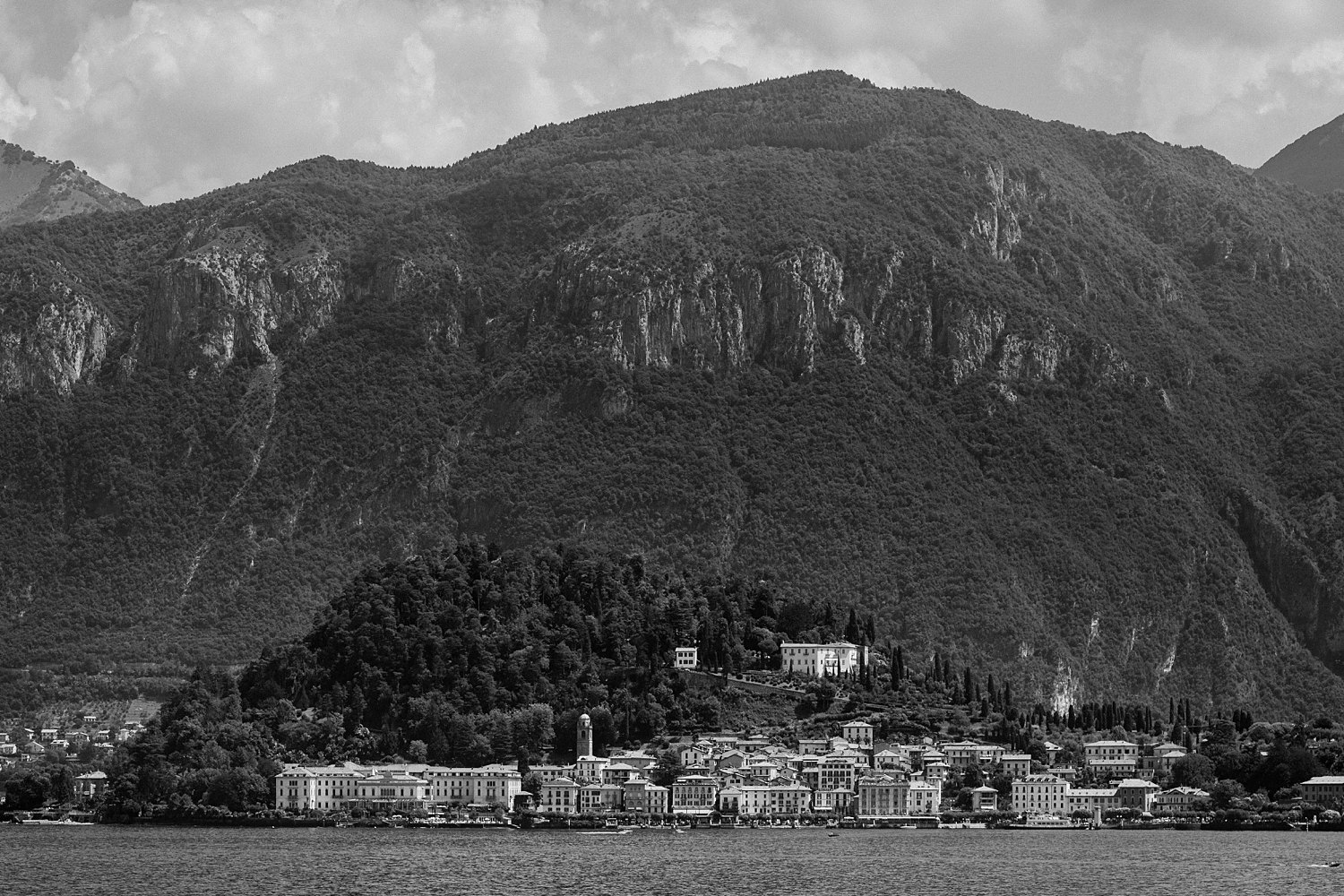 Italian village on the shore of lake Como below mountain Italy black and white