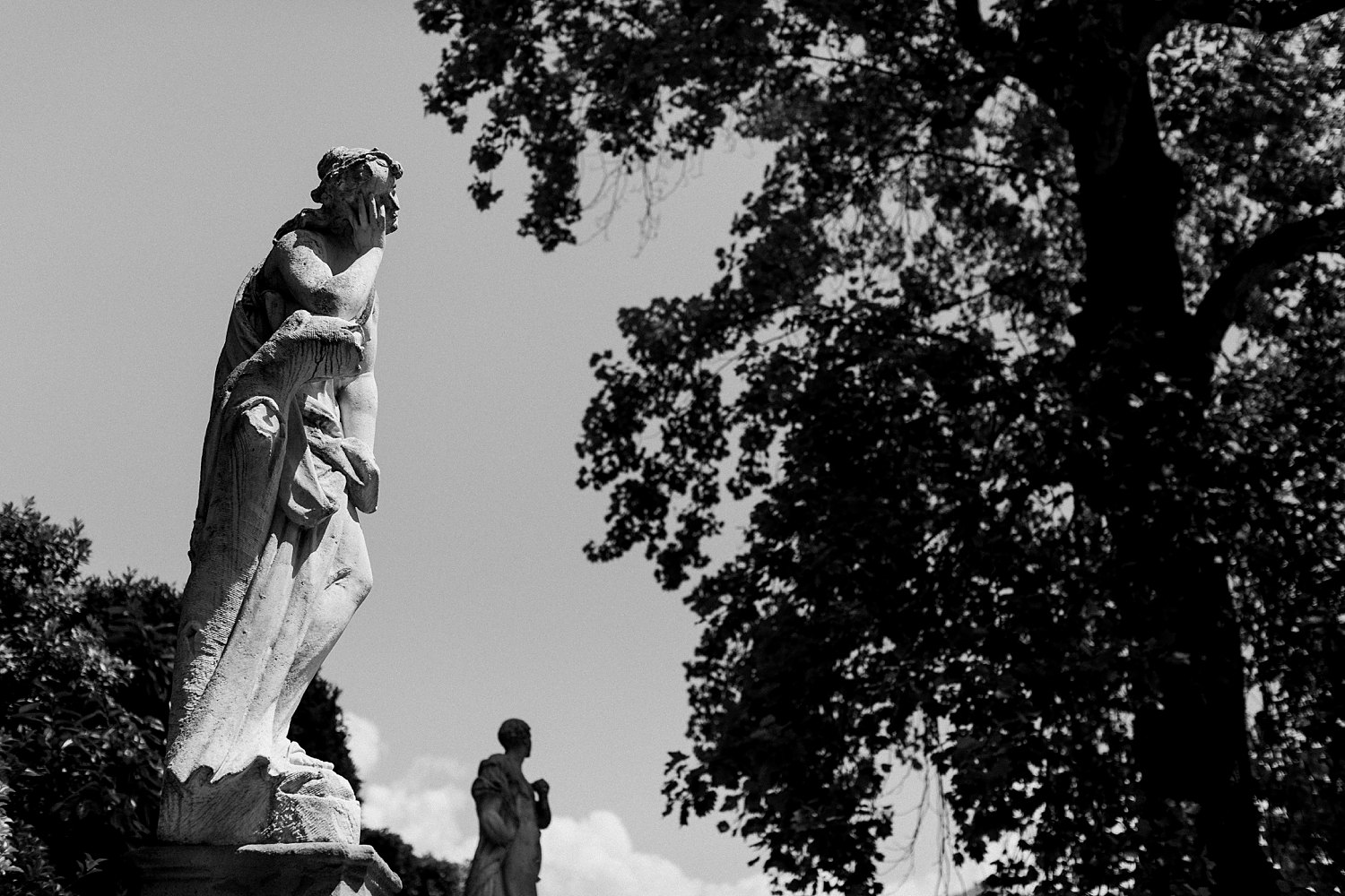Black and white statue of person against sky