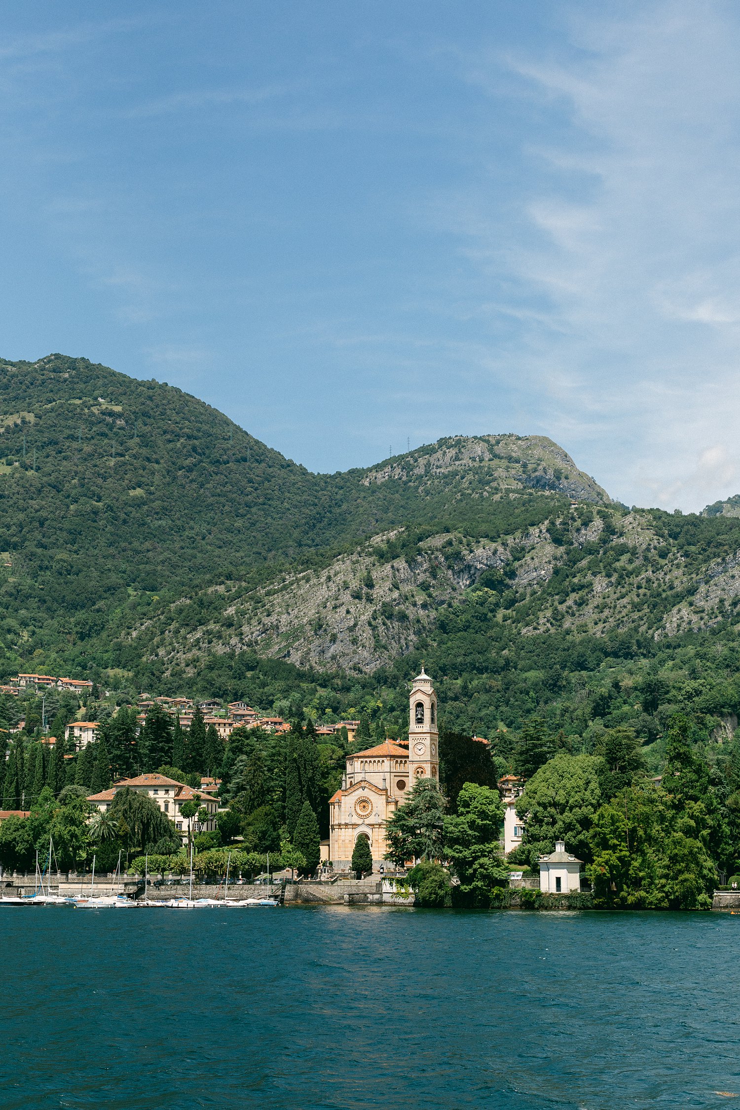 Italy Church tower Lake Como shore in front of green mountains
