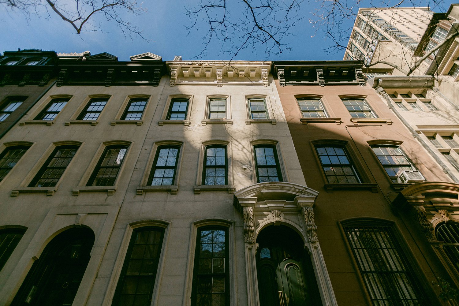 Row town homes Upper East Side Manhattan NYC against blue sky places to visit in new york