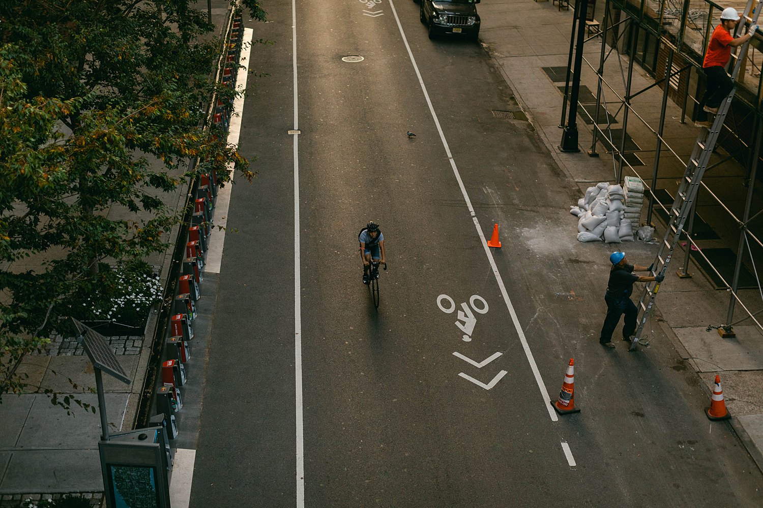Man on bicycle NYC street from above in early morning light places to visit in New York