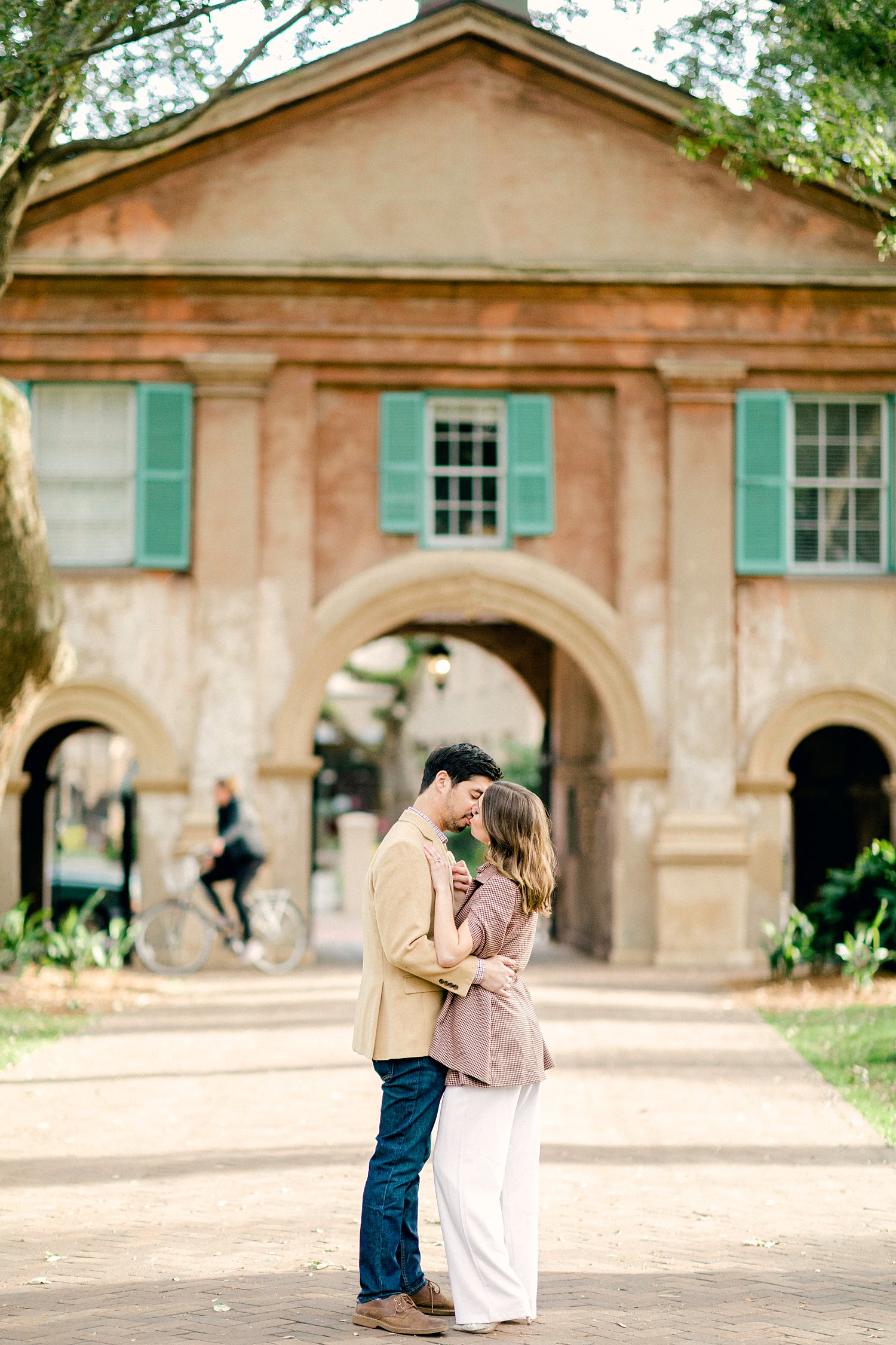 Couple kissing in front of gateway into the College of Charleston