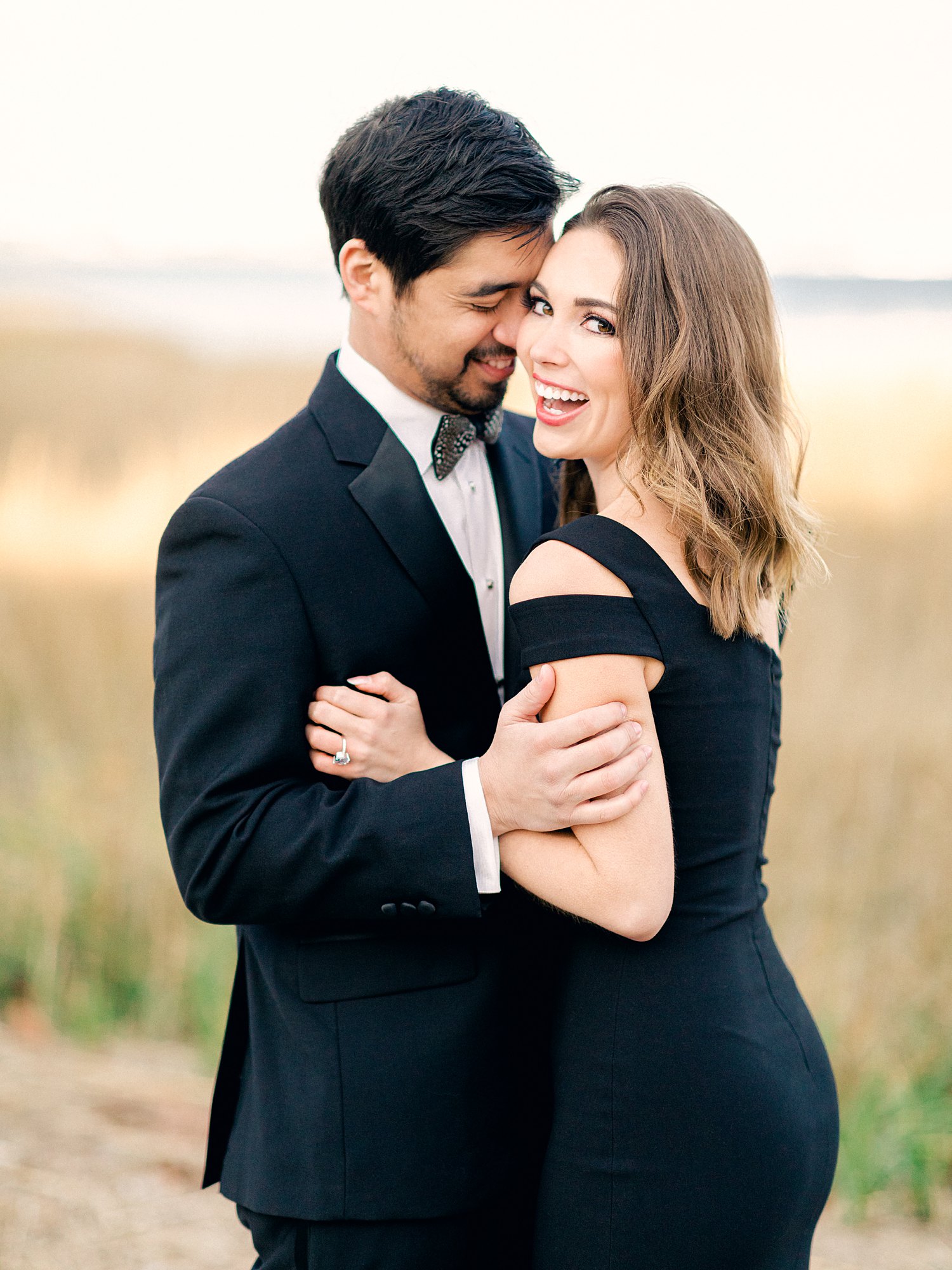 Couple dressed in black laughing as they embrace during Charleston Engagement Session