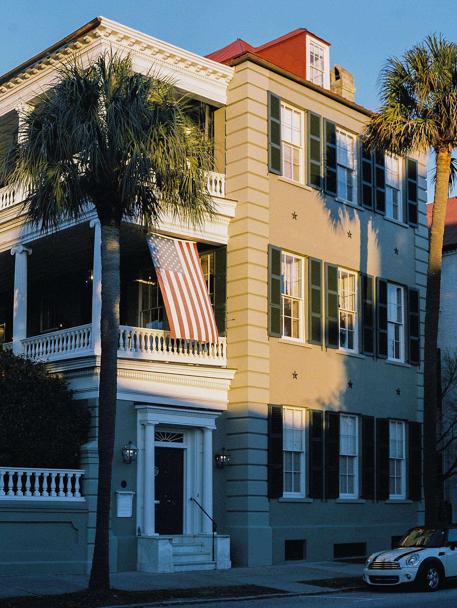 three story home in Charleston South Carolina with palm trees and American flag