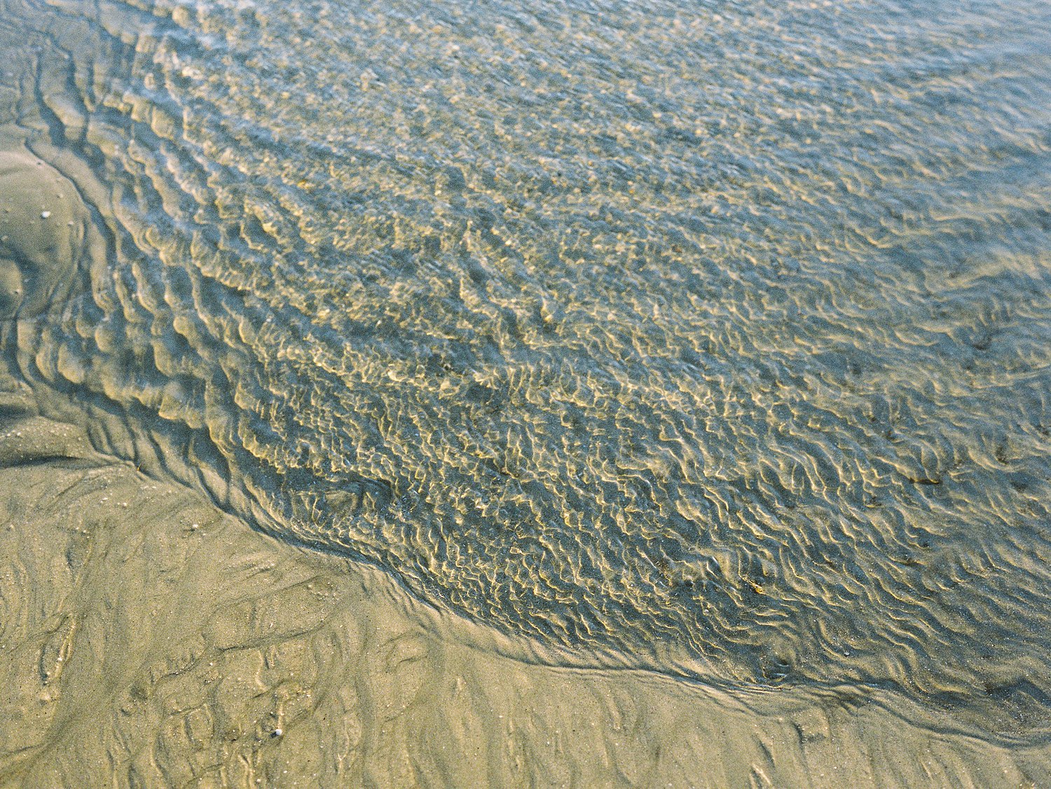 water ripples against tan sand