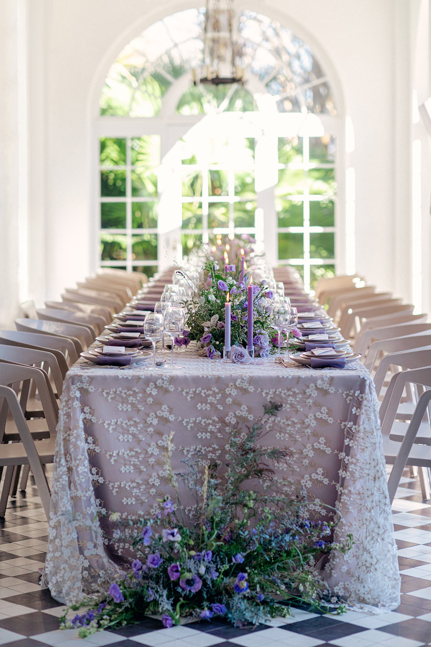 Reception table with purple linen and florals in patio room at Lowndes Grove Charleston Wedding