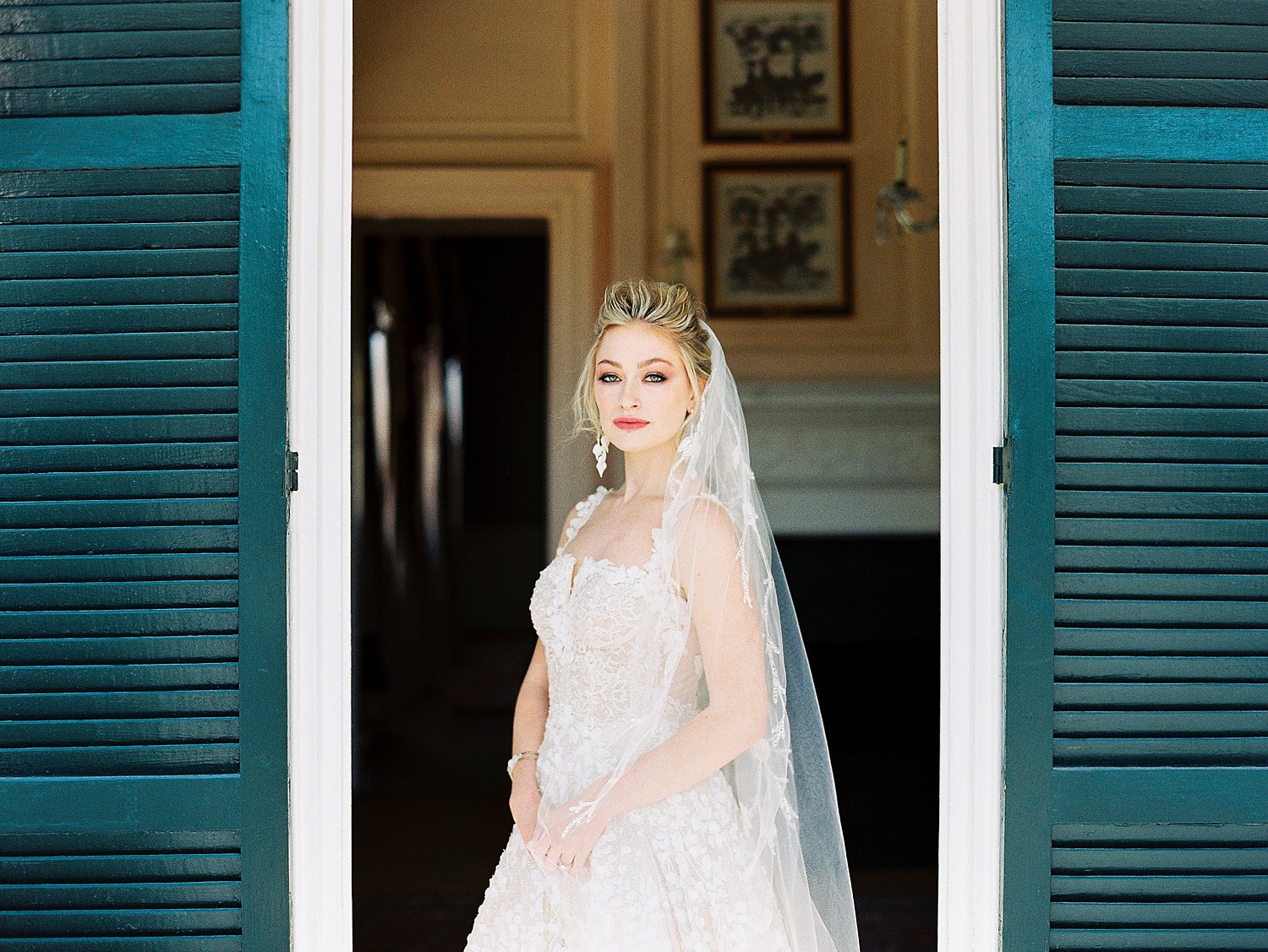 bride in white wedding dress standing in doorway with hands clasped at Lowndes Grove